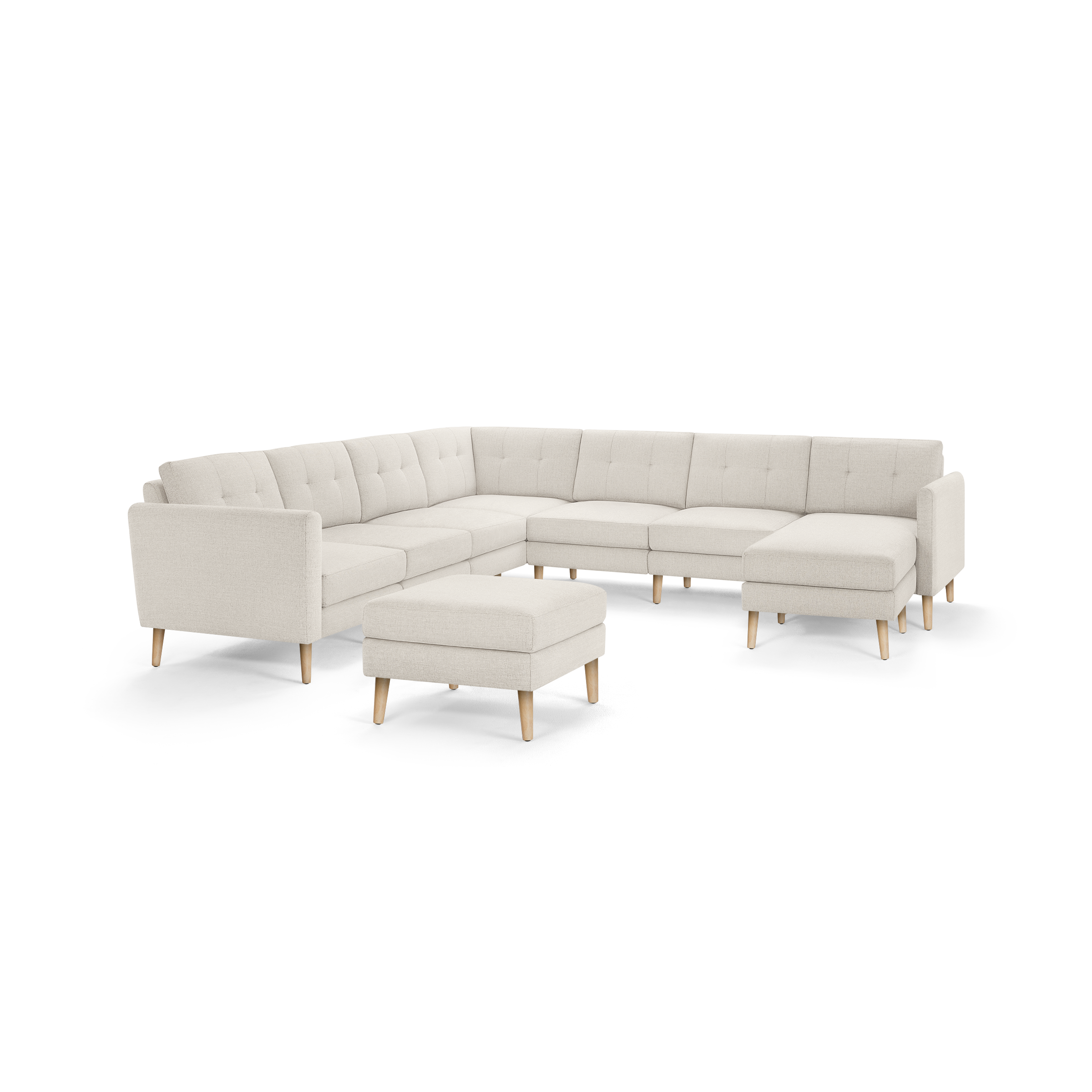 Beige L-shaped sectional sofa with tufted cushions, wooden legs, and matching ottoman on a white background.