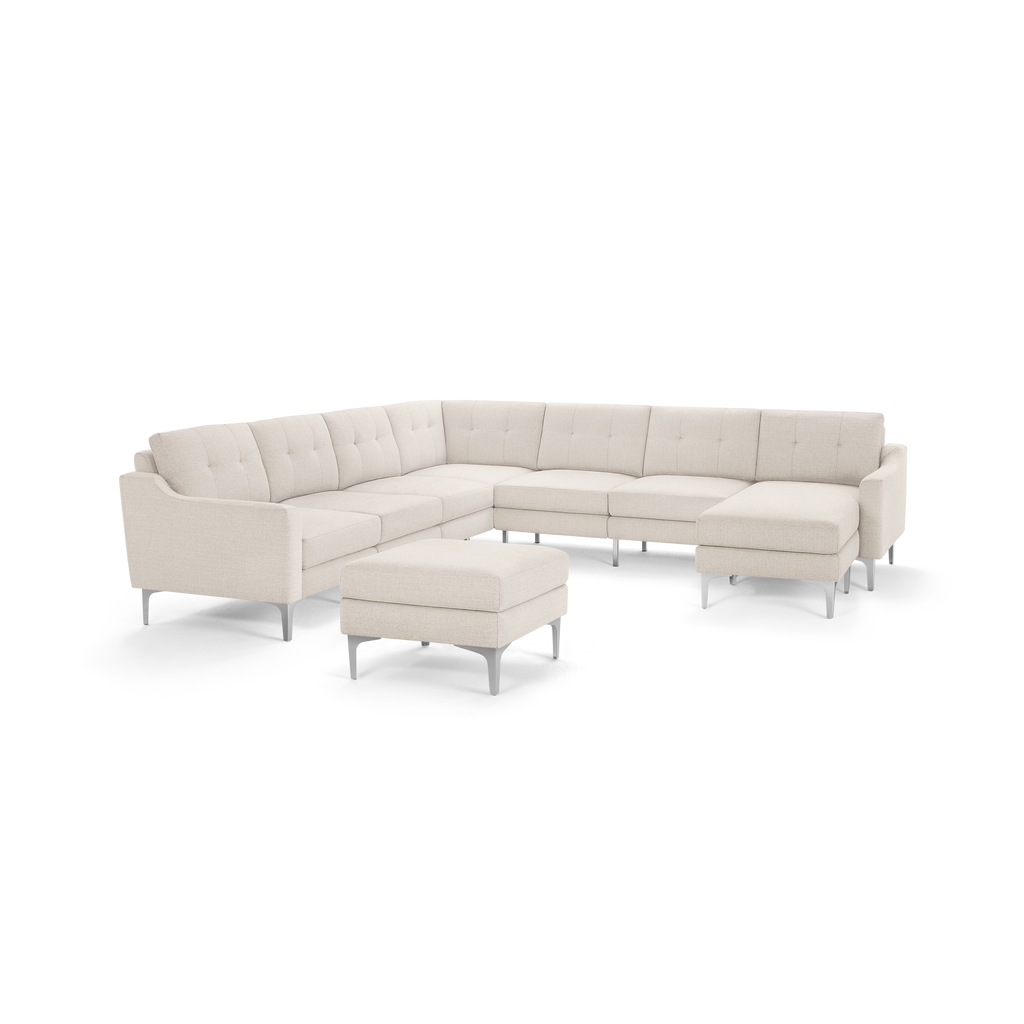 Modern beige L-shaped sectional sofa with tufted cushions, metal legs, and matching ottoman, designed for spacious living rooms.
