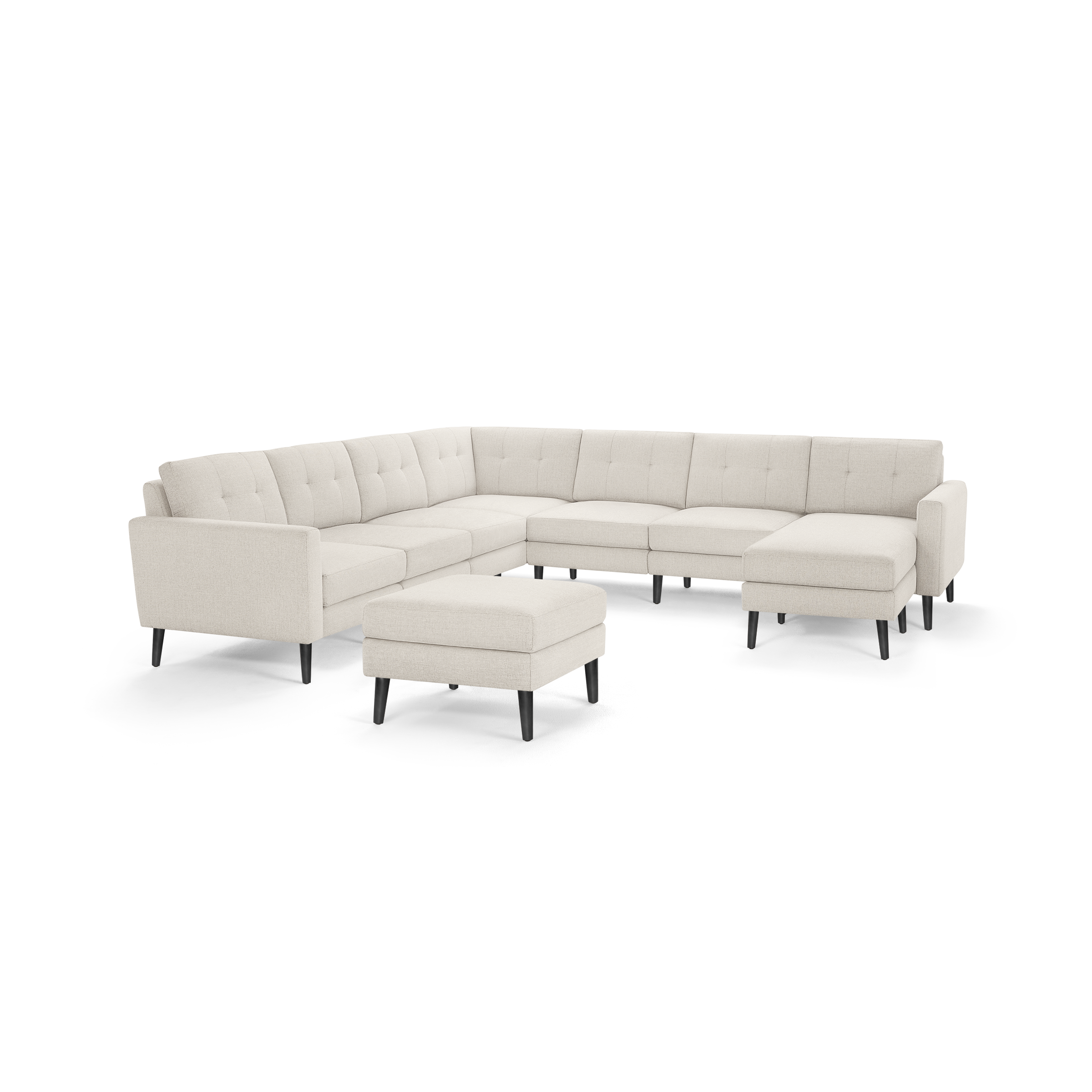 Beige fabric sectional sofa with tufted back cushions, black tapered legs, and matching ottoman on a white background.