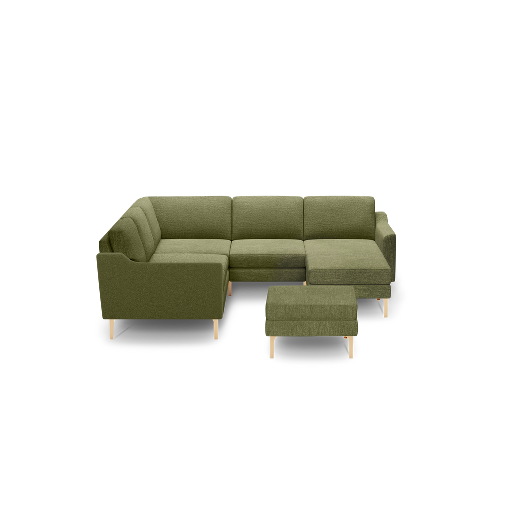 Olive green L-shaped sectional sofa with matching ottoman, wooden legs, and cushioned seating for modern living rooms.