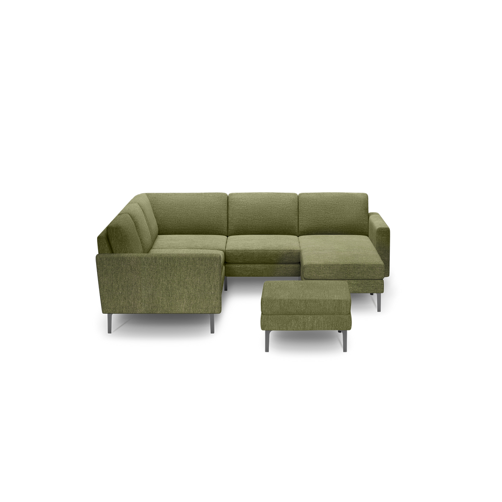 Olive green fabric L-shaped sectional sofa with metal legs and matching ottoman against black background.
