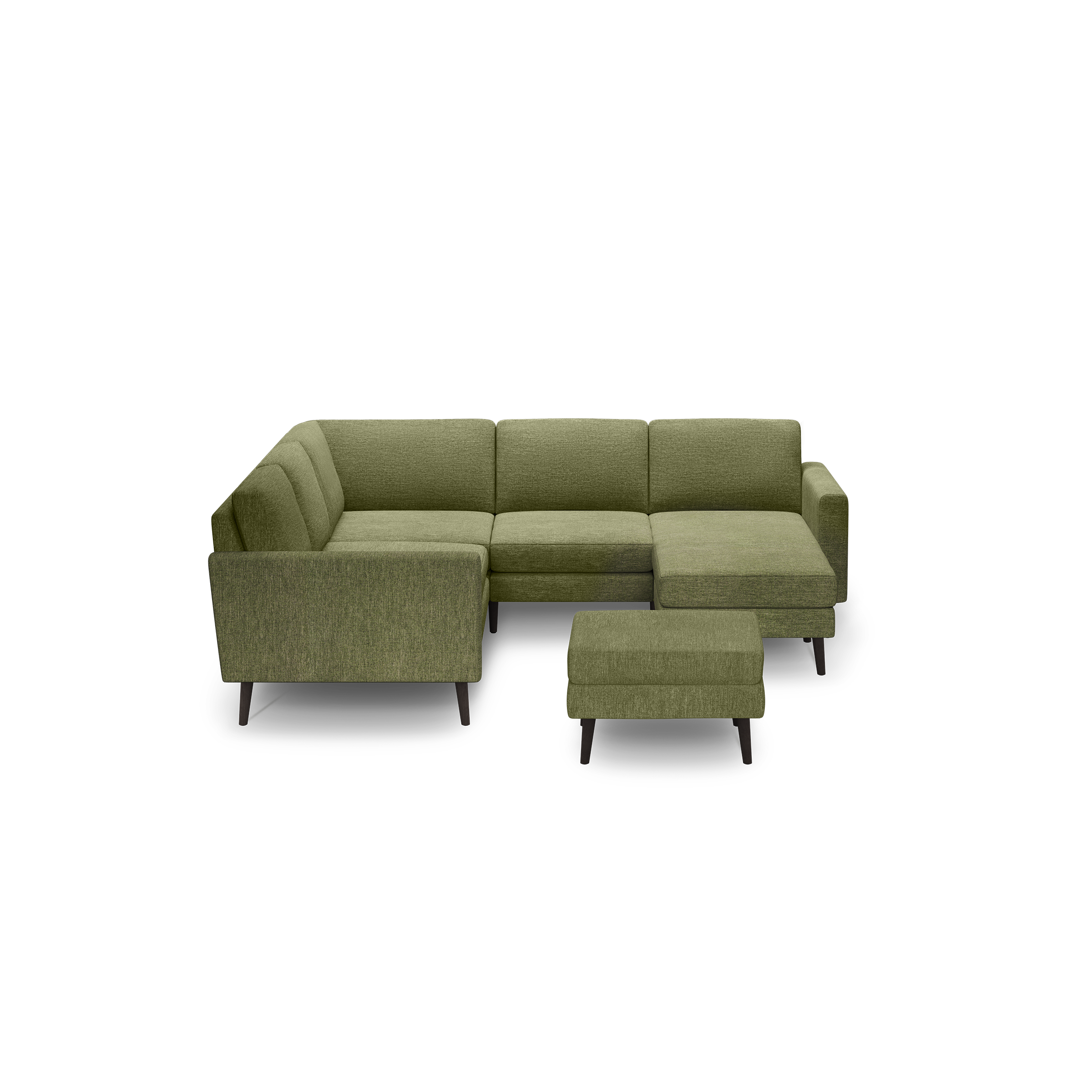 Green fabric L-shaped sectional sofa with tufted back cushions and matching ottoman on dark wooden legs, isolated on black background.