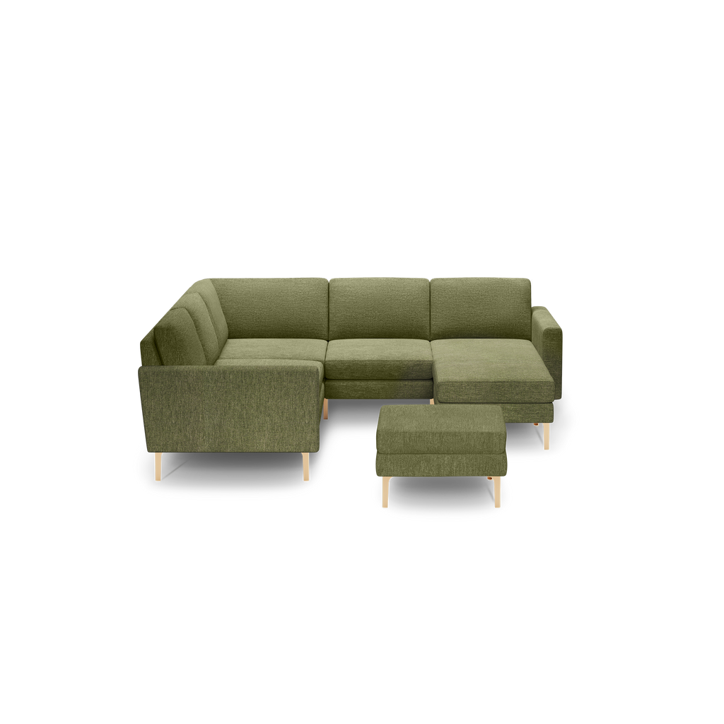 Olive green L-shaped sectional sofa with matching ottoman, wooden legs, and cushioned armrests, modern minimalist design.