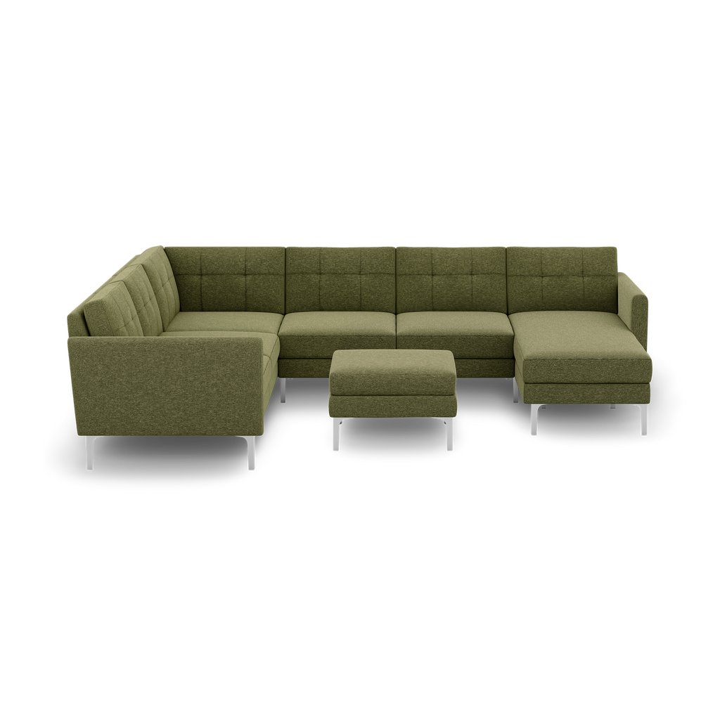 Green fabric L-shaped sectional sofa with tufted cushions and matching ottoman on metal legs, isolated on black background.