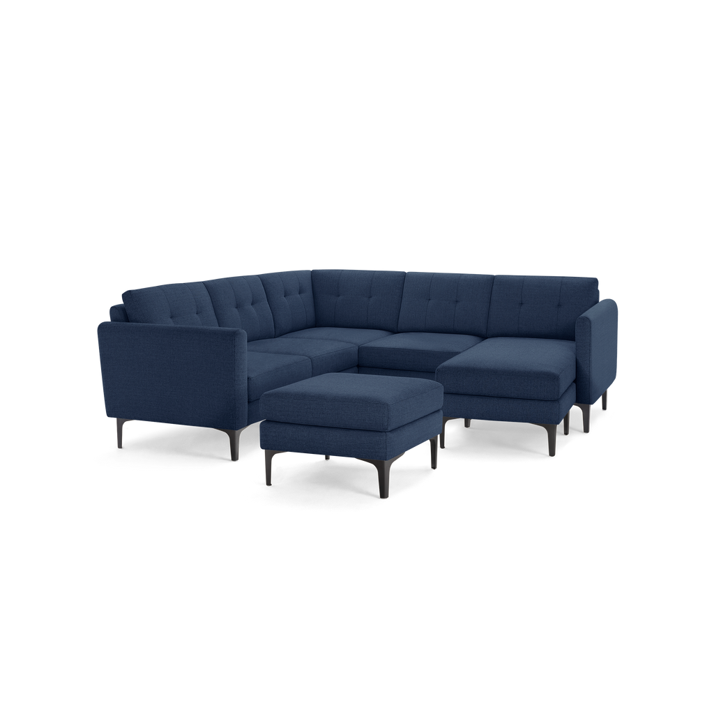 Modern navy blue fabric sectional sofa with tufted cushions, L-shape design, black metal legs, and a matching ottoman.