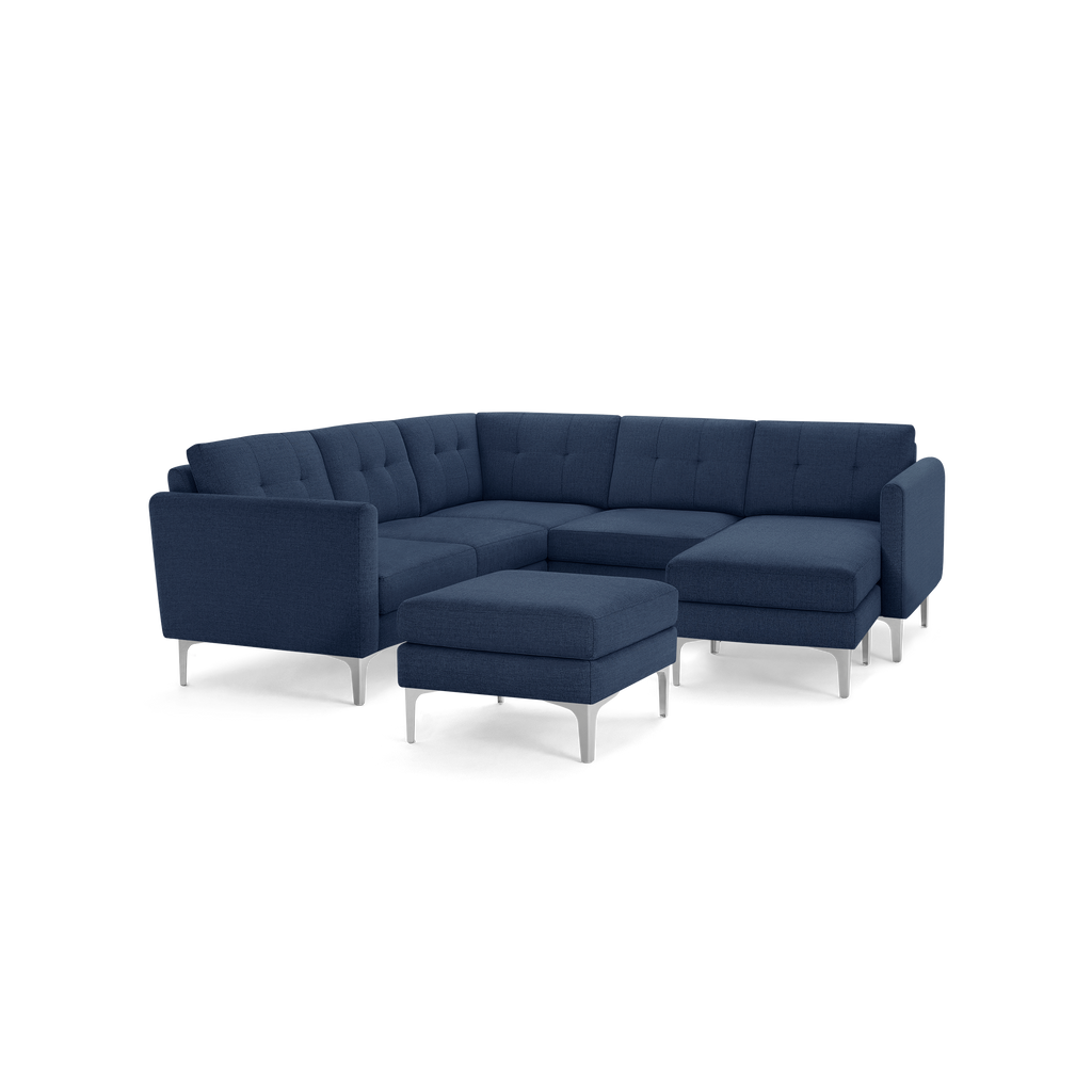 Modern navy blue fabric sectional sofa with metal legs and matching ottoman, featuring tufted cushions and clean lines.