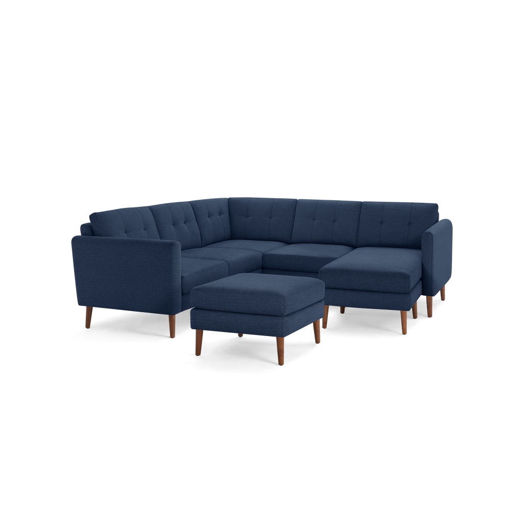 Modern navy blue fabric sectional sofa with tufted cushions, wooden legs, and matching square ottoman for versatile seating.
