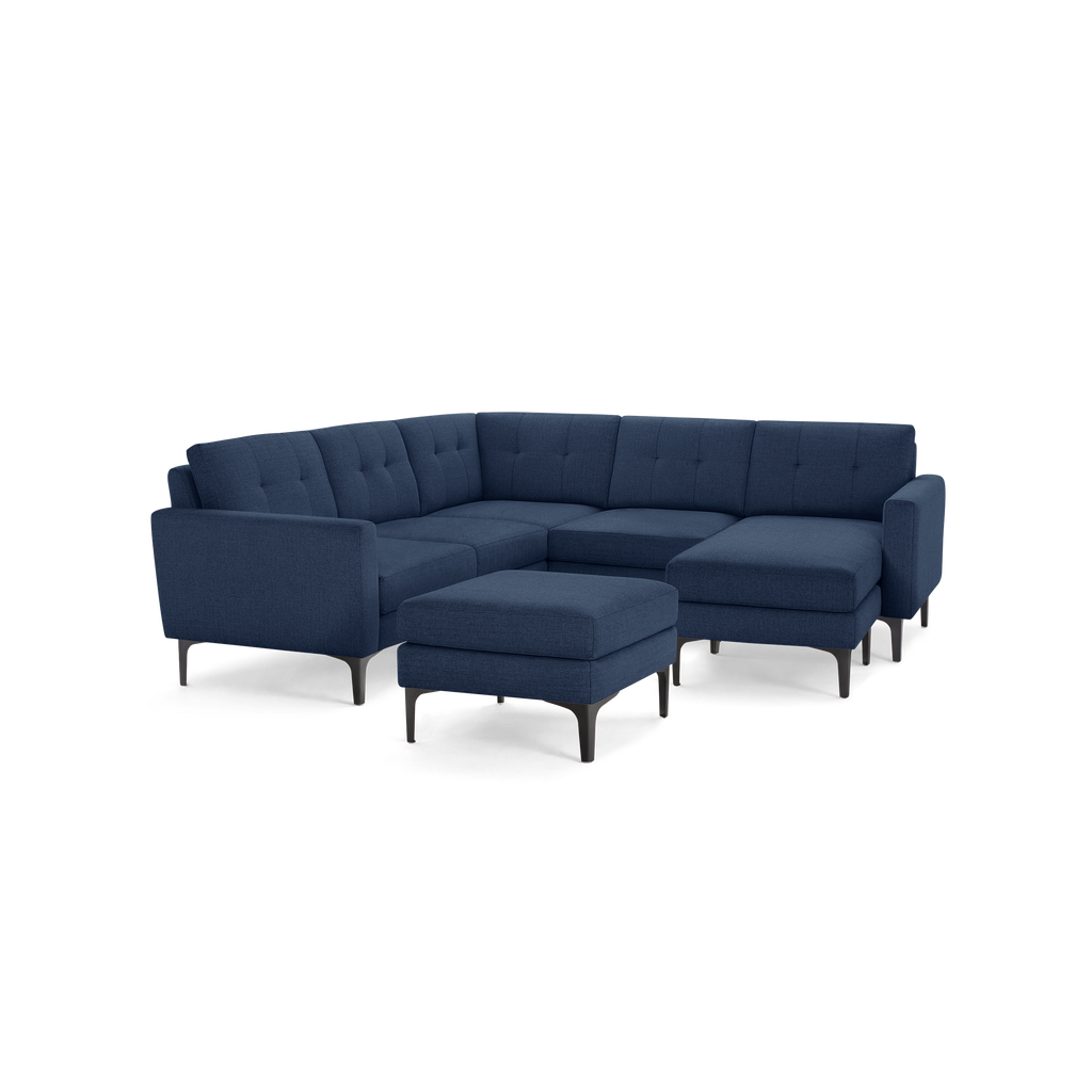 Modern navy blue fabric sectional sofa with tufted back cushions and matching ottoman on metal legs.