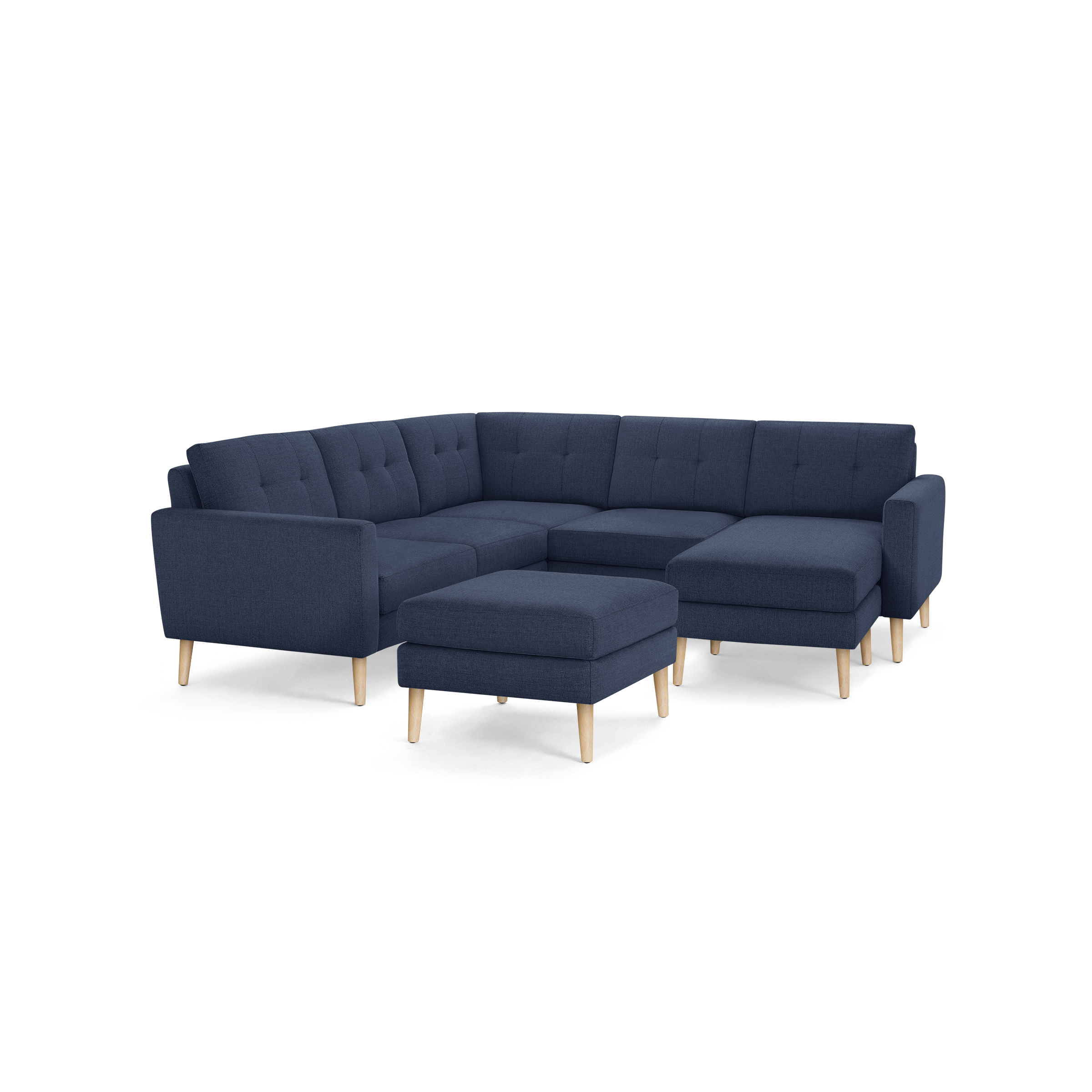 Modern navy blue fabric sectional sofa with tufted cushions and light wooden legs, including a matching ottoman.
