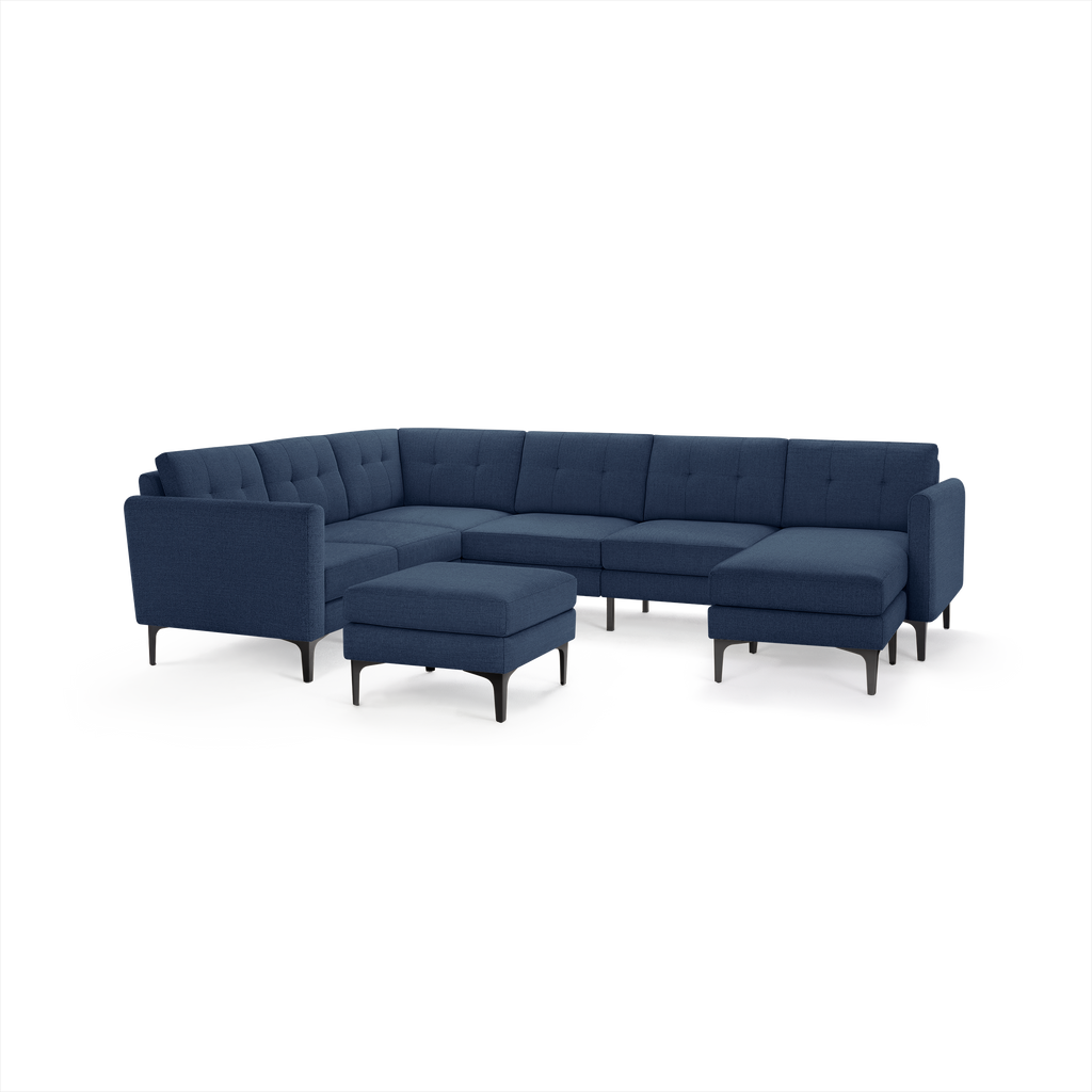 Modern navy blue sectional sofa with tufted cushions and matching ottoman, featuring sleek black legs and clean lines.