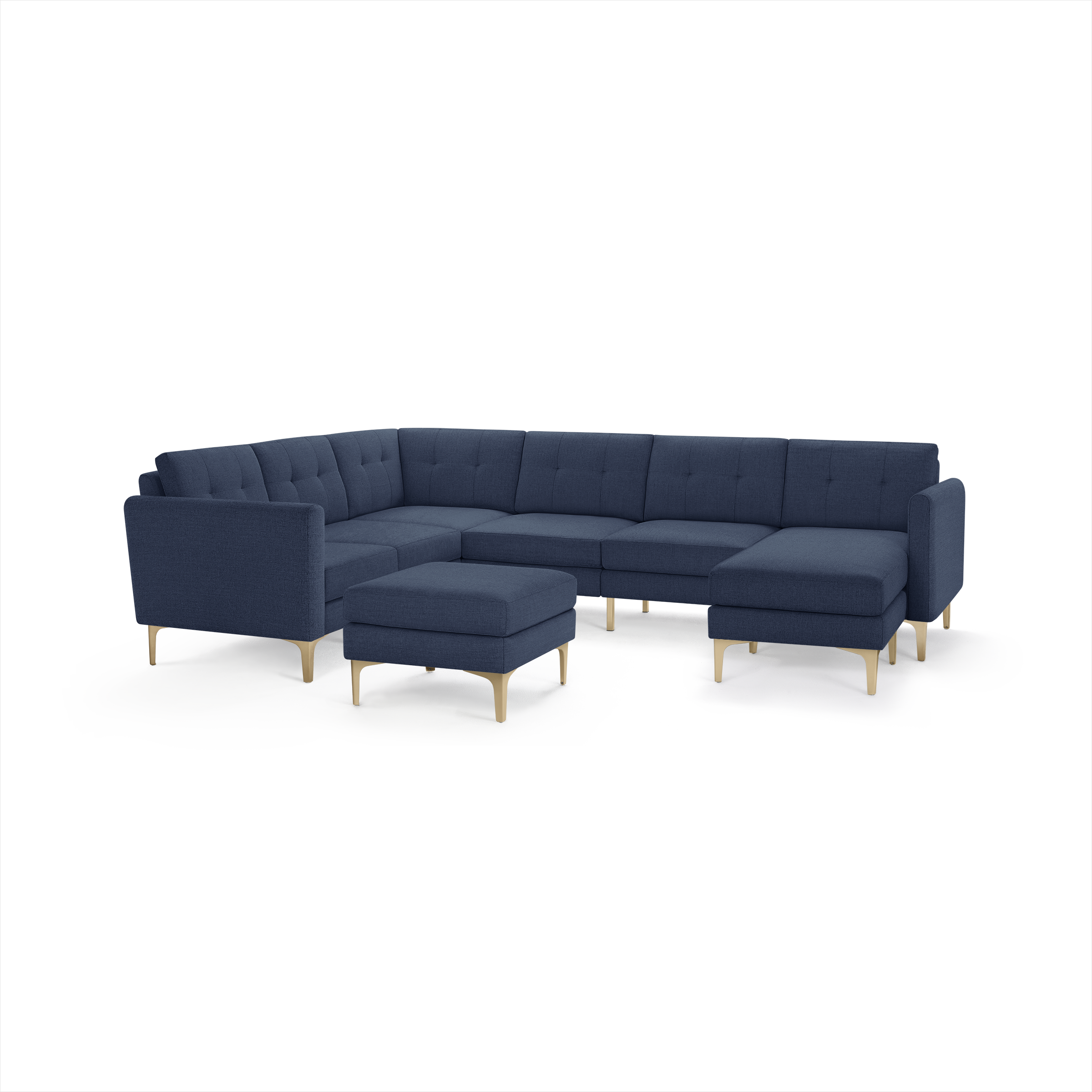 Large L-shaped sectional sofa in dark blue fabric with tufted cushions and light wooden legs, includes matching ottoman.