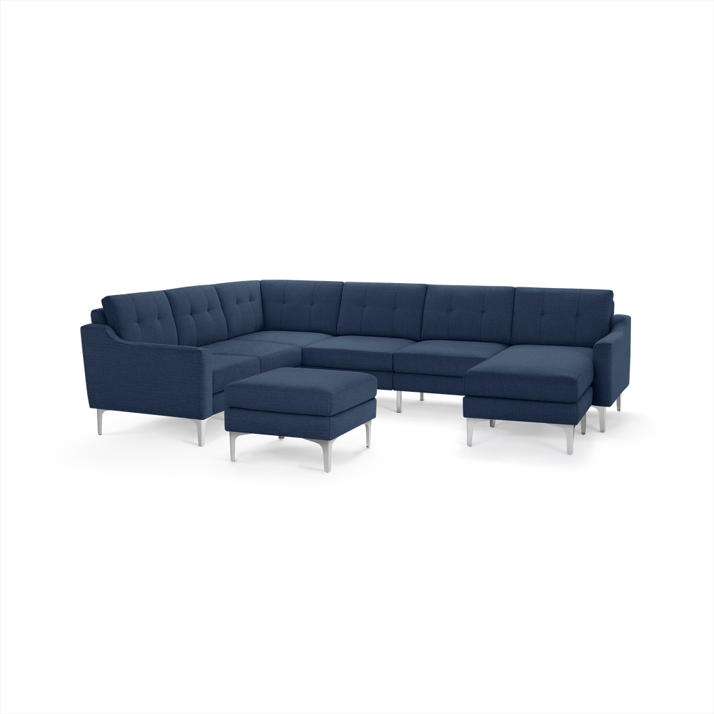 Modern navy blue fabric sectional sofa with tufted cushions, metal legs, and a matching ottoman, designed for spacious living areas.
