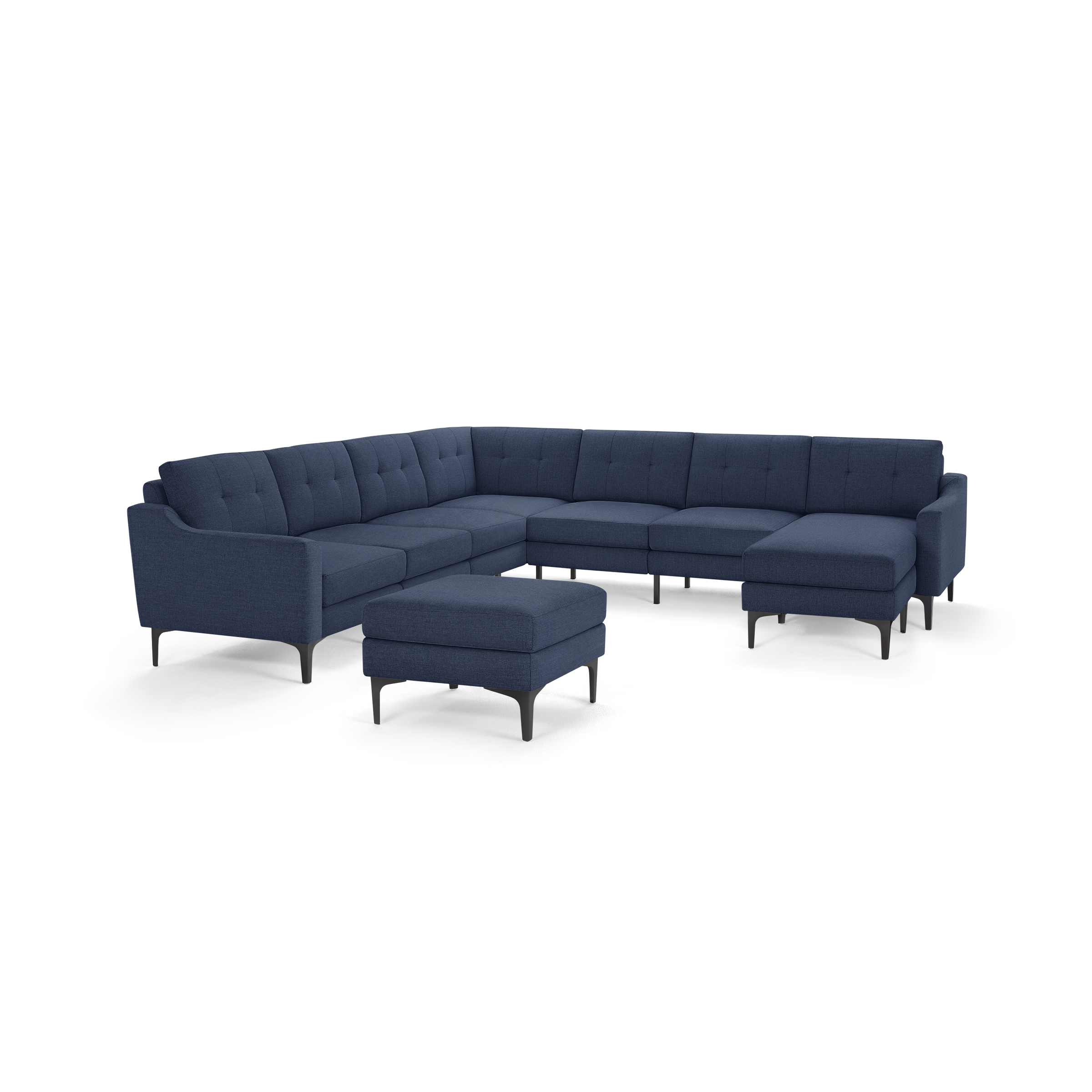 Large modern navy blue fabric sectional sofa with tufted cushions, metal legs, and matching ottoman, isolated on white background.