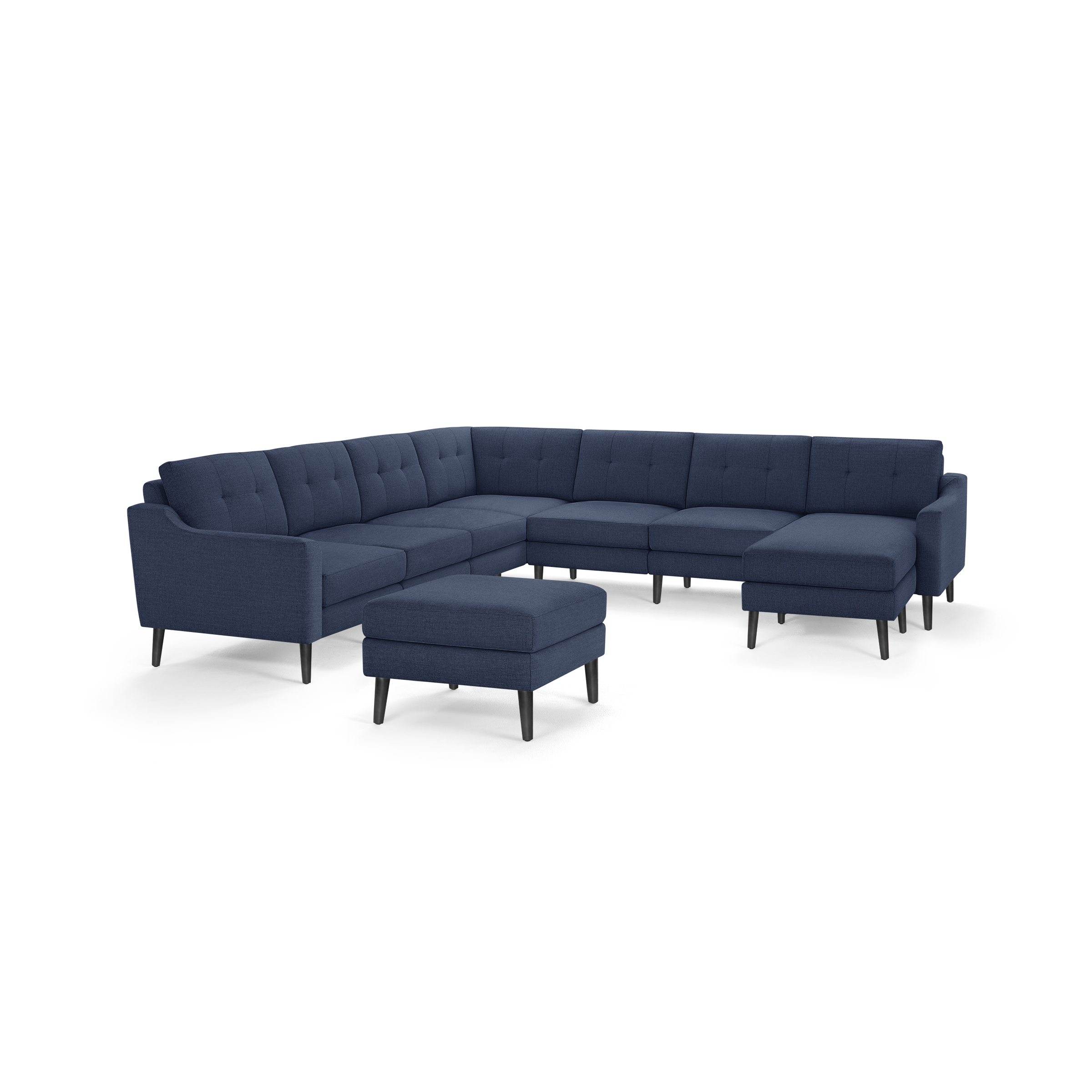 Modern navy blue fabric L-shaped sectional sofa with tufted back cushions and matching ottoman, featuring angled wooden legs.