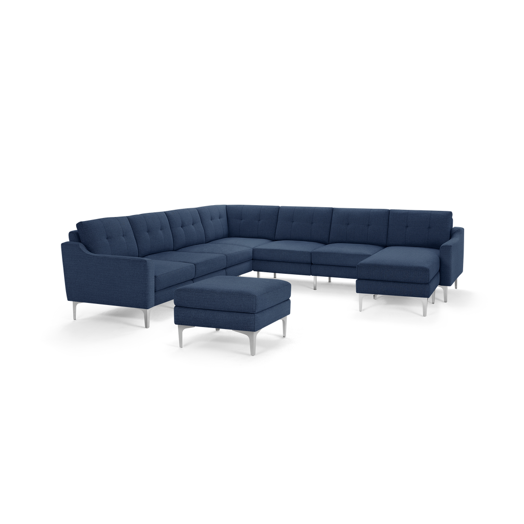 Modern L-shaped sectional sofa in dark blue fabric with tufted cushions and metal legs, includes matching ottoman.