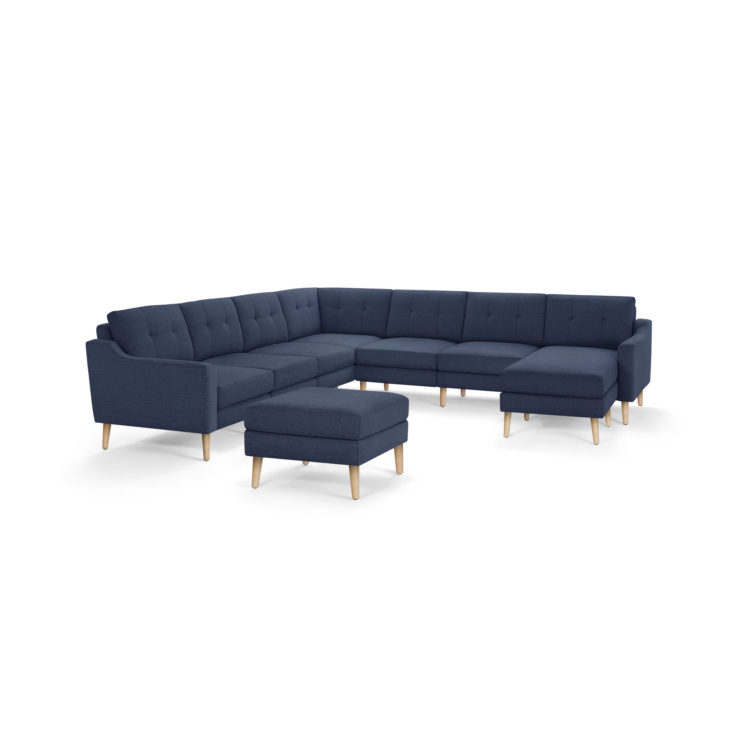 Modern navy blue fabric sectional sofa with tufted back cushions and light wooden legs, accompanied by matching ottoman.