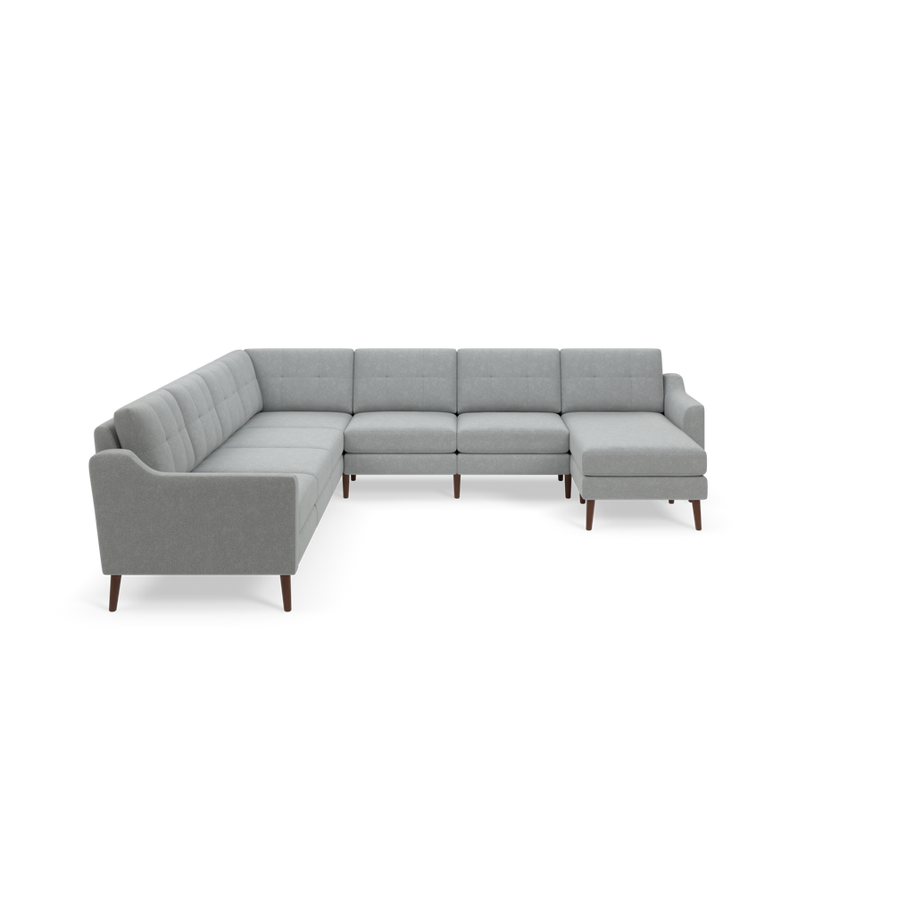 Light gray fabric sectional sofa with tufted back cushions and wooden legs, featuring an L-shaped design with a chaise lounge on the right side.