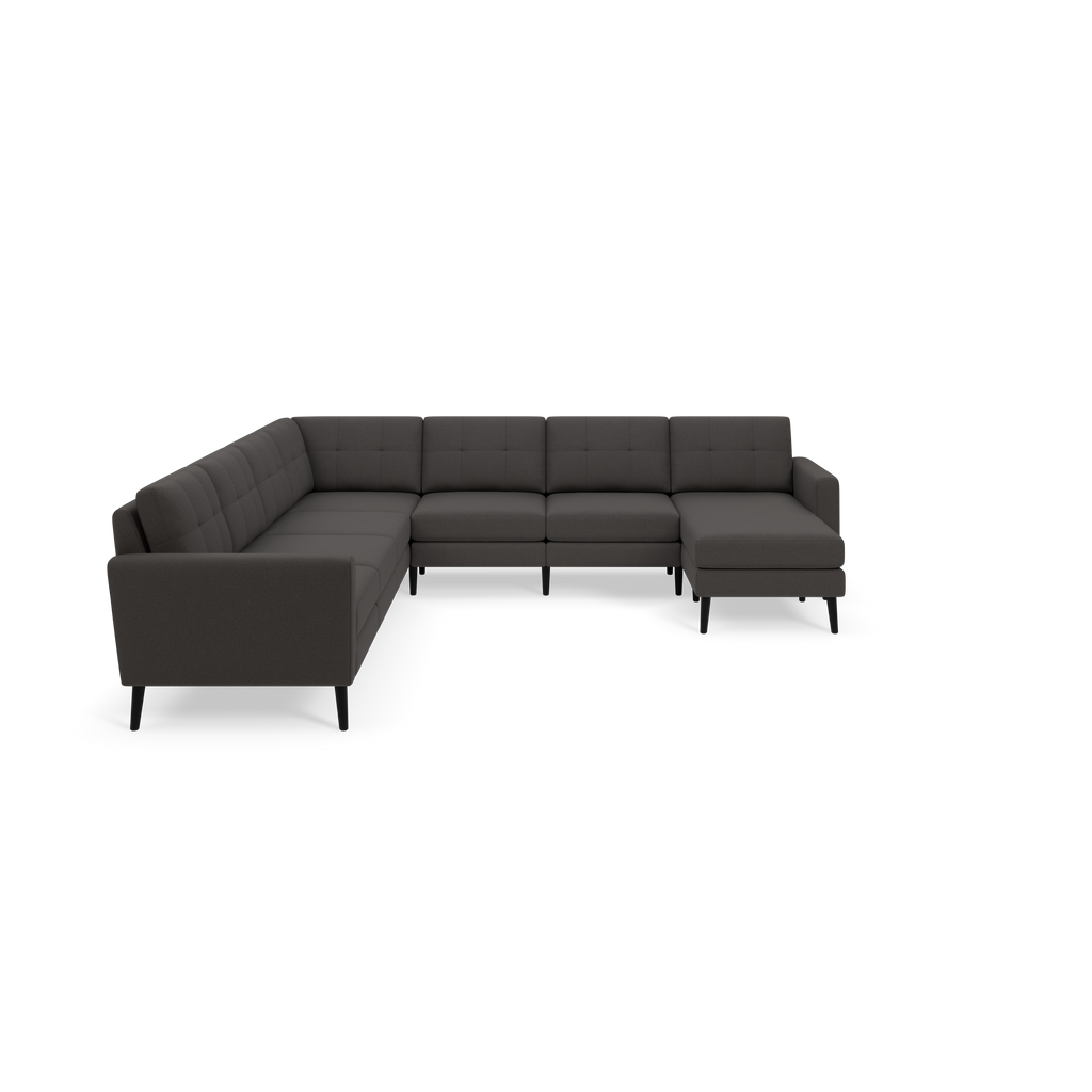 Modern dark gray fabric sectional sofa with tufted back cushions and black tapered wooden legs on a black background.