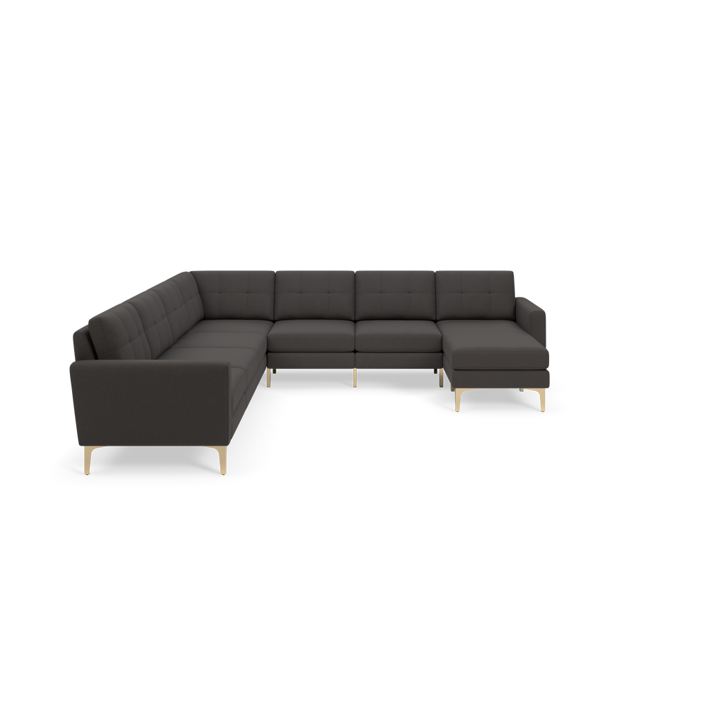 Dark gray L-shaped sectional sofa with tufted cushions and light wooden legs on a black background.