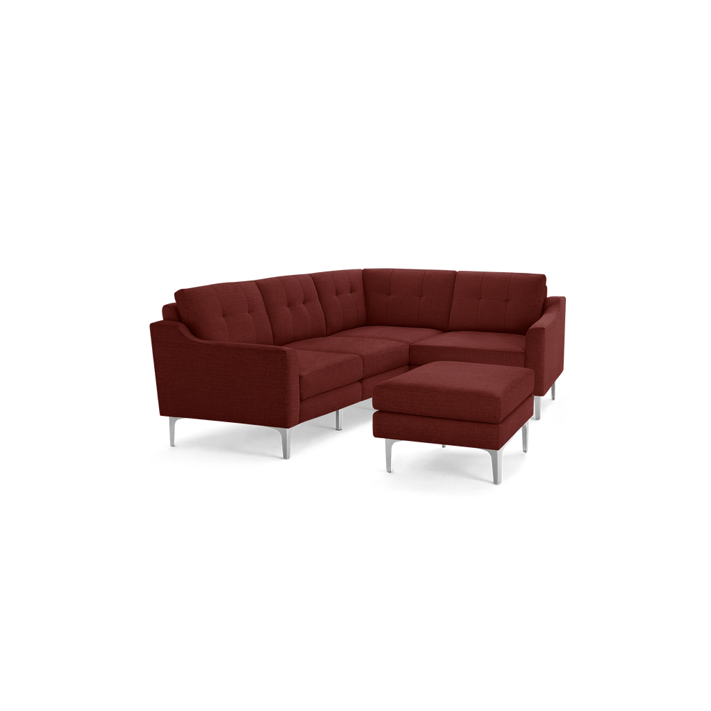 L-shaped sectional sofa with deep red fabric upholstery, tufted back cushions, and sleek silver metal legs with a matching ottoman.
