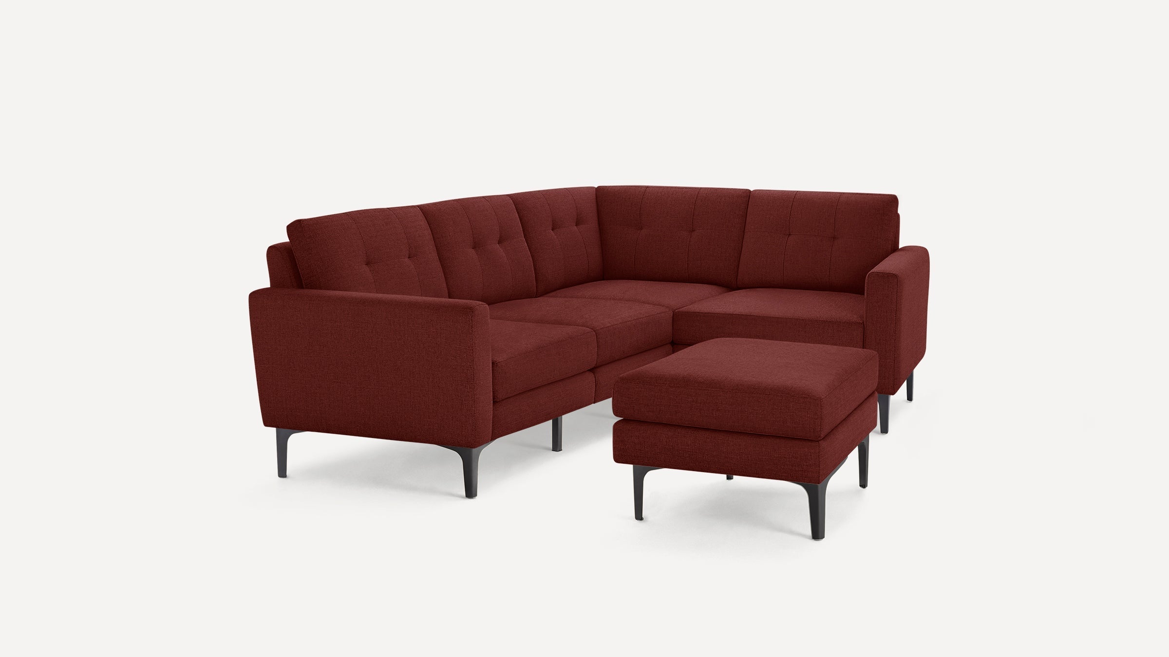 Modern L-shaped sectional sofa with matching ottoman, upholstered in deep red fabric and supported by black metal legs.