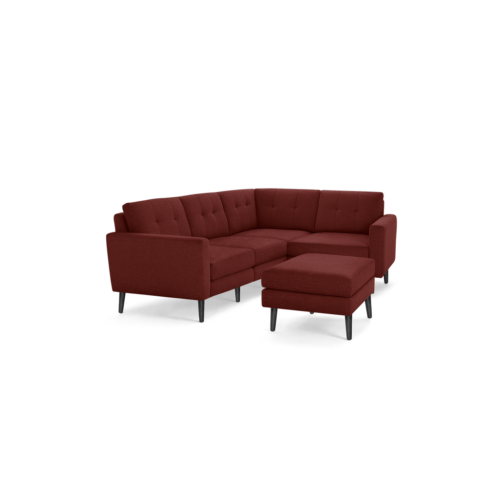 Modern L-shaped sectional sofa with matching ottoman, upholstered in deep red fabric, featuring tufted cushions and dark wooden legs.