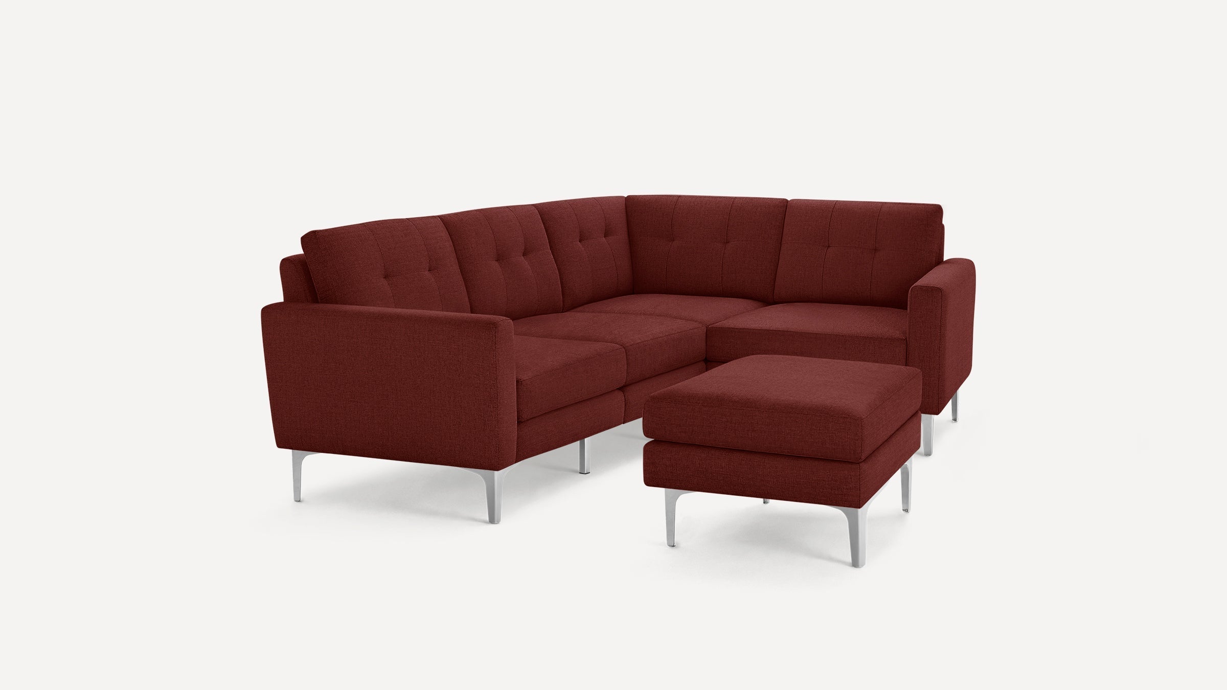 Modern L-shaped sectional sofa with deep red upholstery, tufted cushions, and sleek silver metal legs, including a matching ottoman.