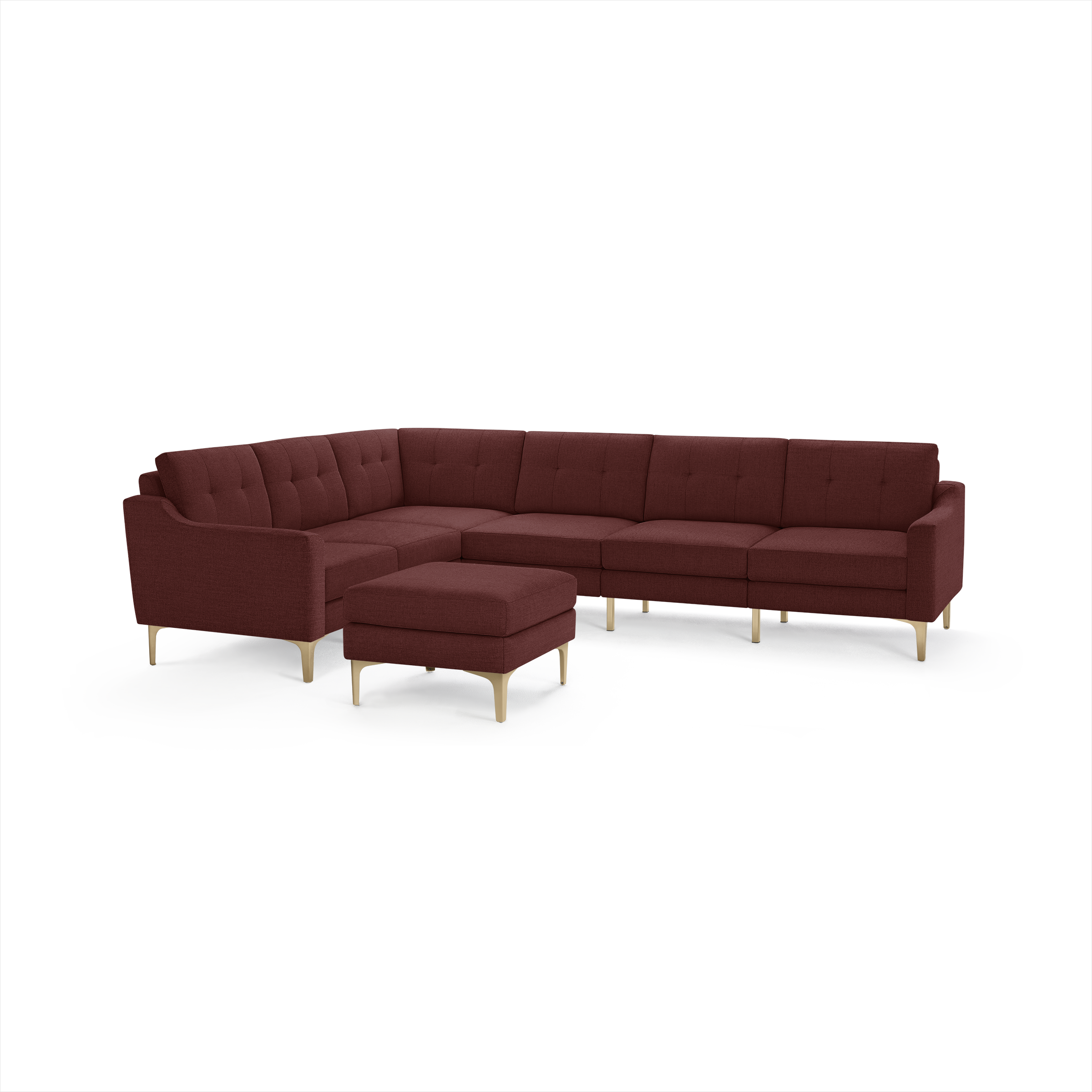 Modern L-shaped sectional sofa and ottoman in deep burgundy fabric with tufted cushions and light wooden legs, perfect for spacious living rooms.