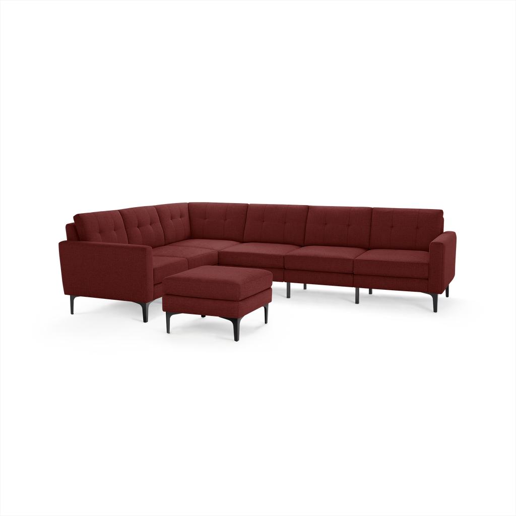 Modern L-shaped sectional sofa in deep burgundy fabric with tufted back cushions and black metal legs, accompanied by matching ottoman.