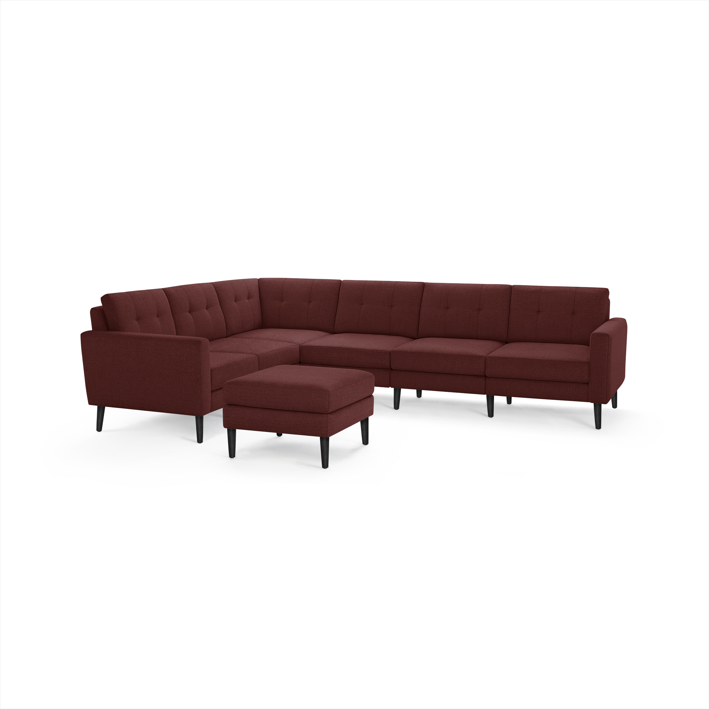 Modern L-shaped sectional sofa in deep burgundy fabric with tufted cushions, matching ottoman, and sleek black legs.