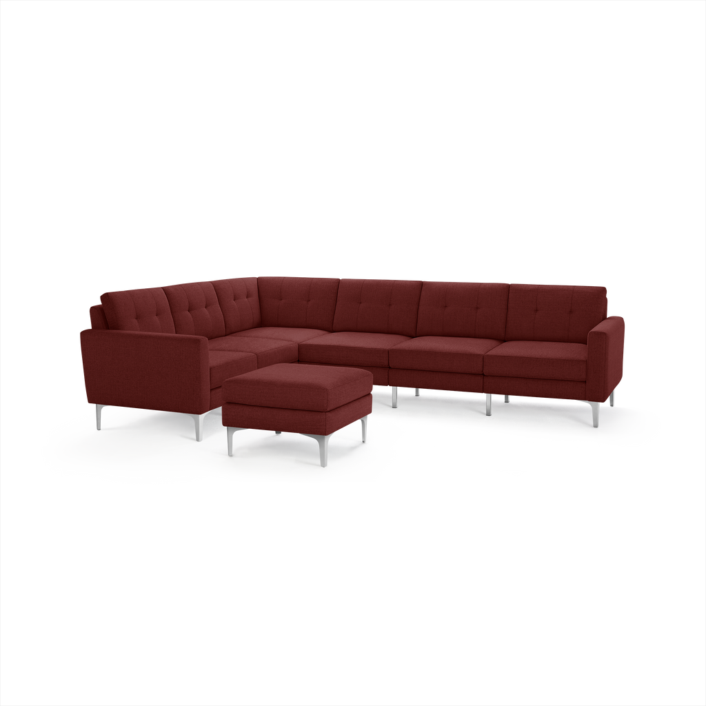 Modern L-shaped sectional sofa in deep red fabric with tufted cushions and sleek silver metal legs, accompanied by a matching ottoman.