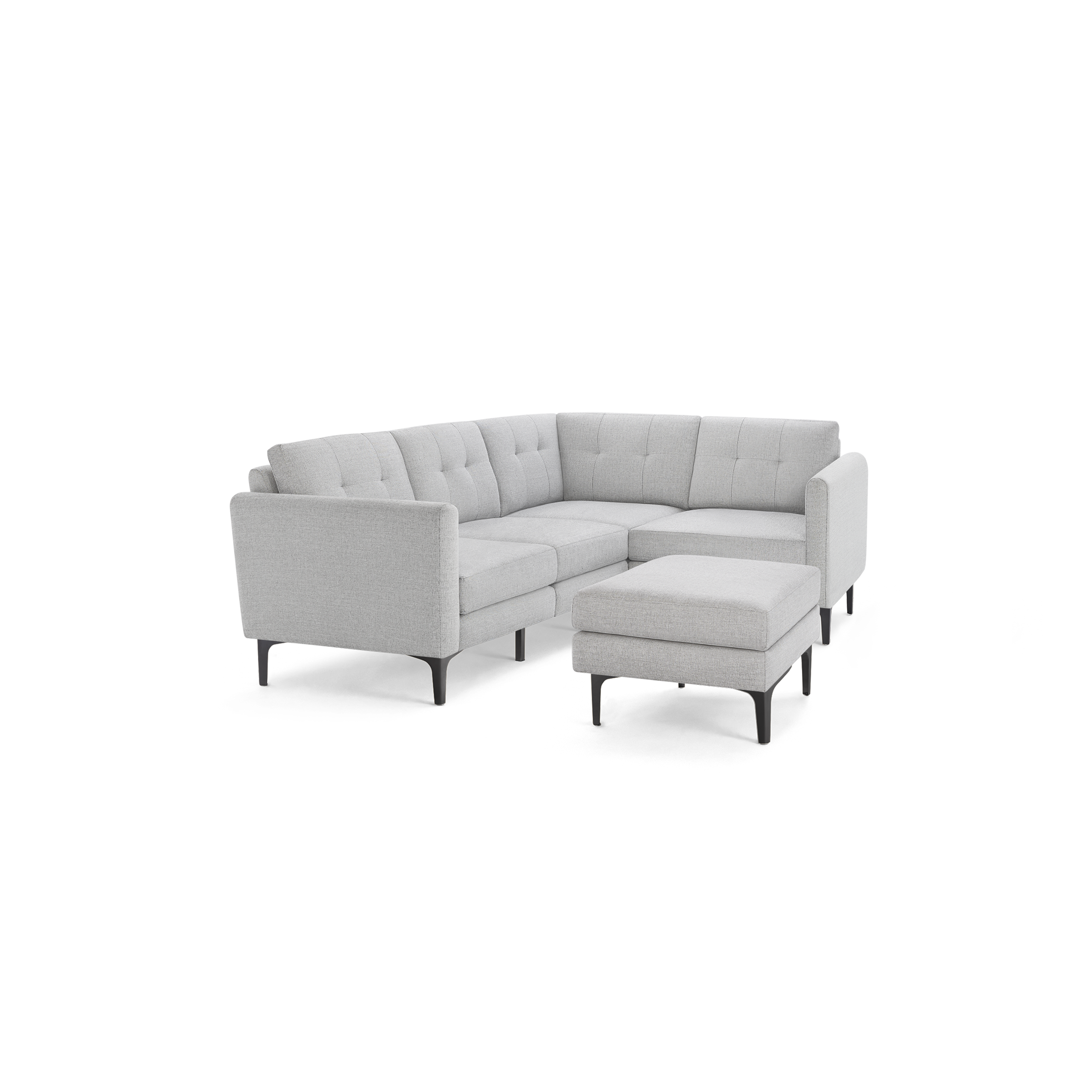 Light gray L-shaped sectional sofa with button-tufted cushions and matching ottoman, supported by slim black legs.