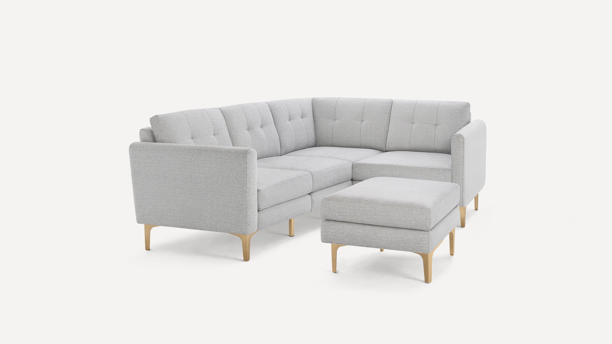 Light gray modern L-shaped sectional sofa with tufted cushions and light wooden legs, accompanied by a matching ottoman.
