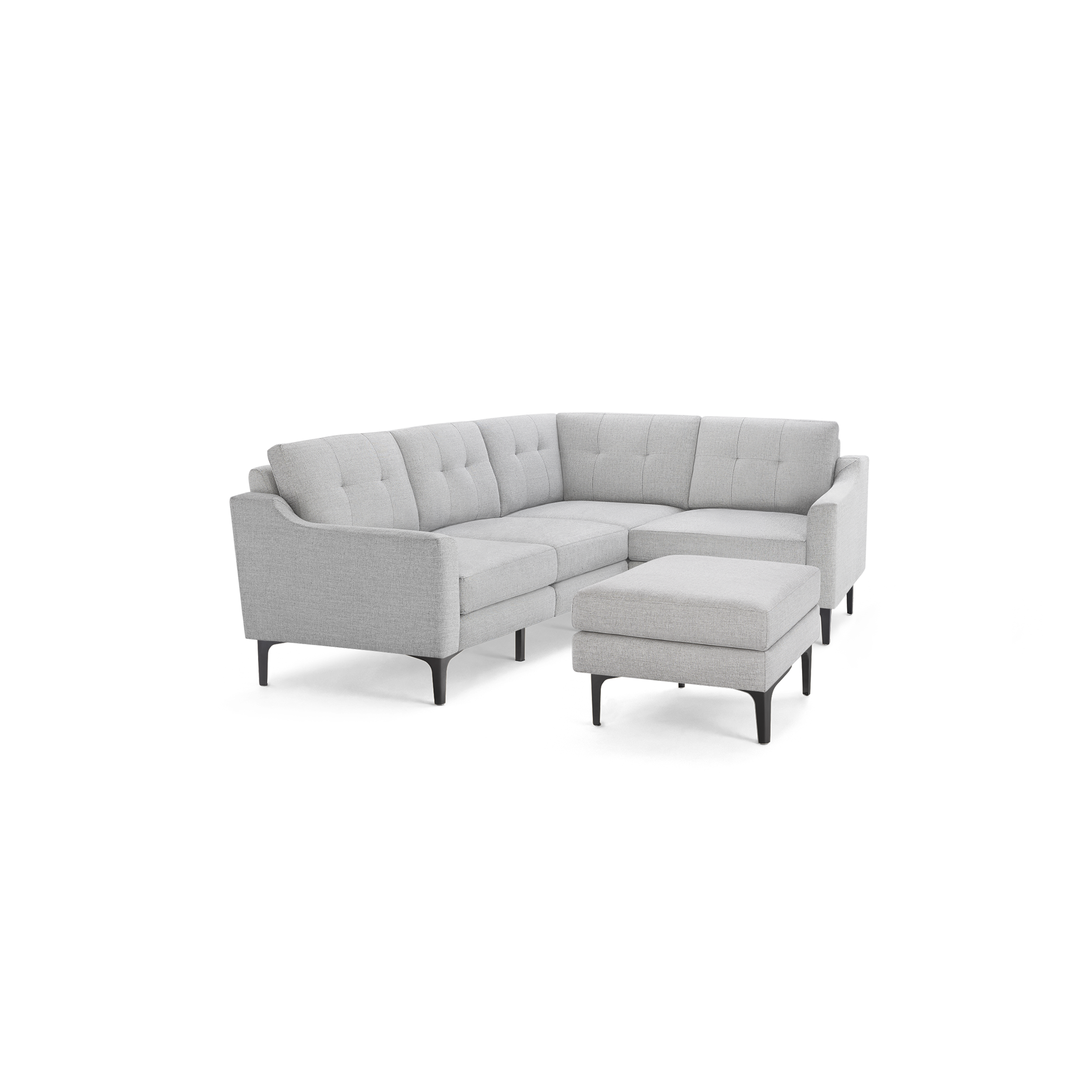 Light gray fabric L-shaped sectional sofa with tufted back cushions, slim black legs, and matching ottoman.