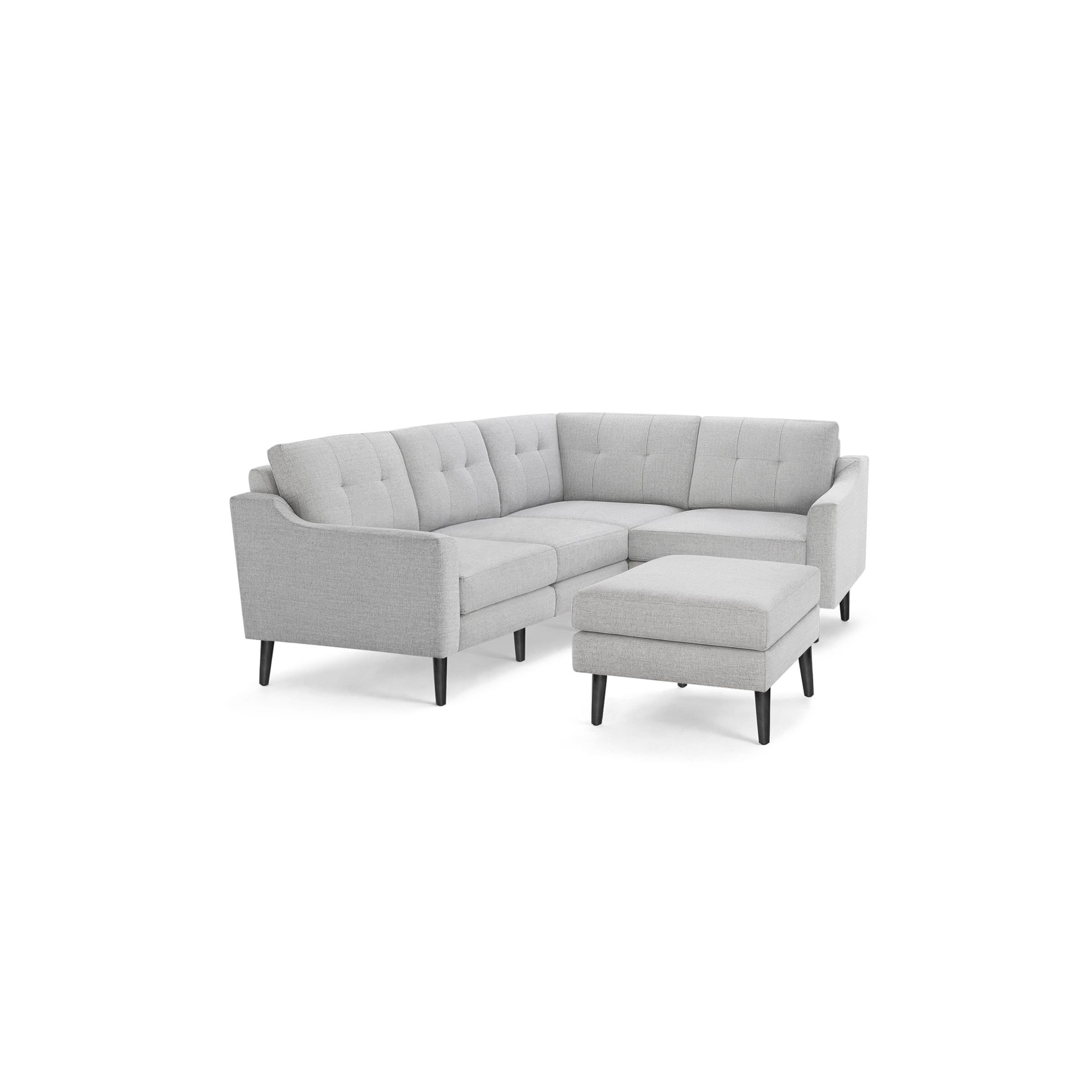 Light gray fabric L-shaped sectional sofa with tufted cushions and matching ottoman on dark wooden legs.