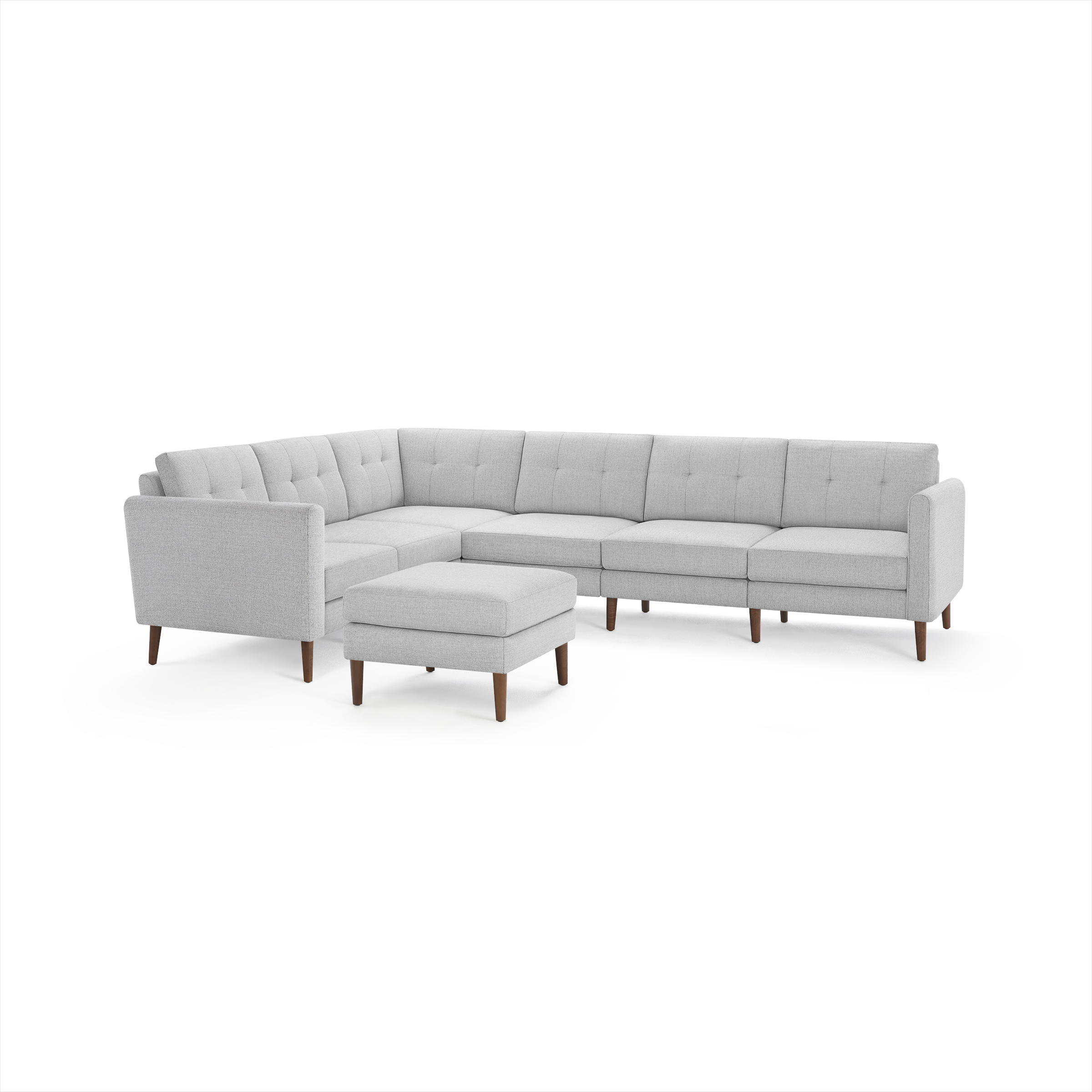 Light gray modern sectional sofa with tufted cushions and wooden legs, including a matching ottoman.