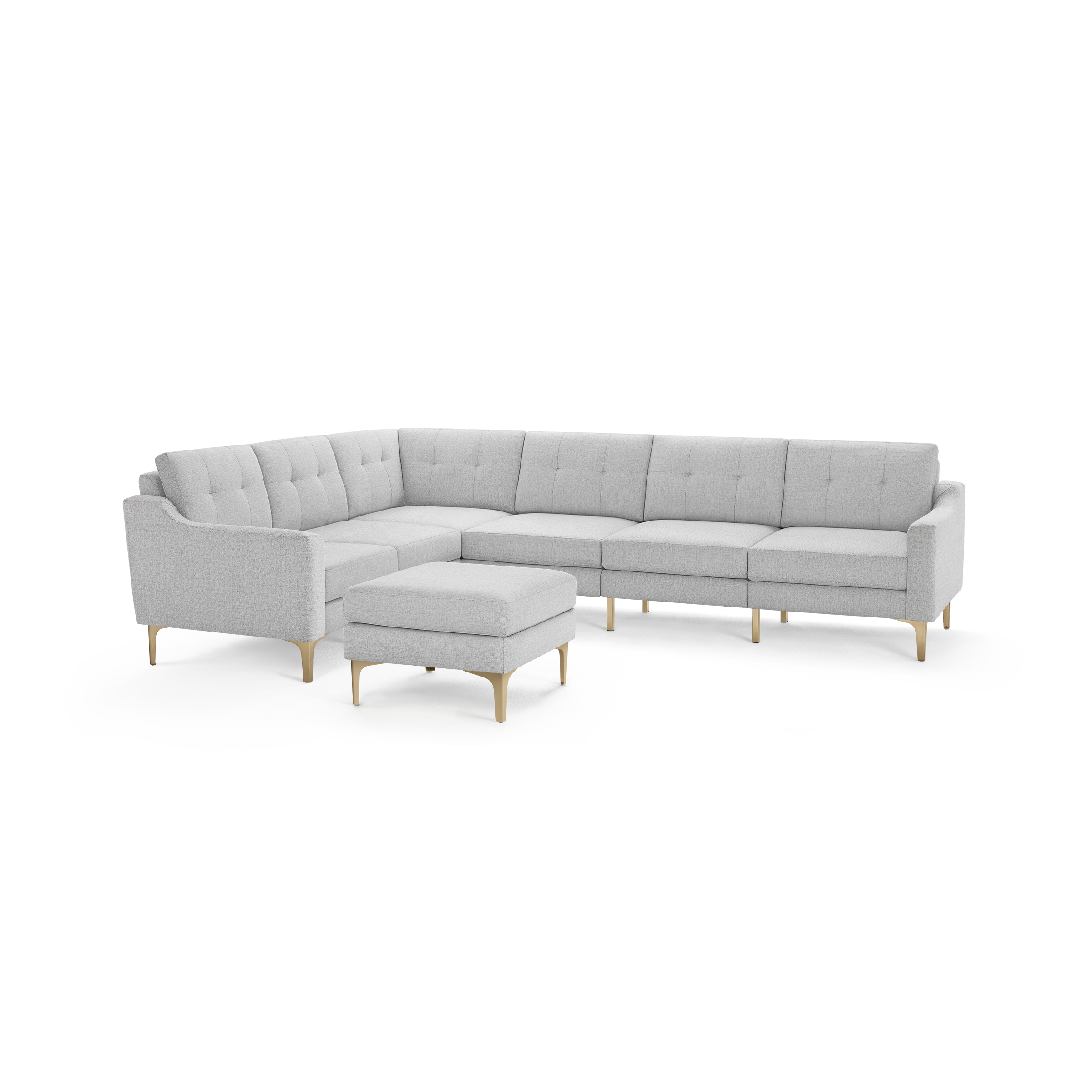 Light gray upholstered L-shaped sectional sofa with tufted cushions and a matching ottoman, supported by light wooden legs.