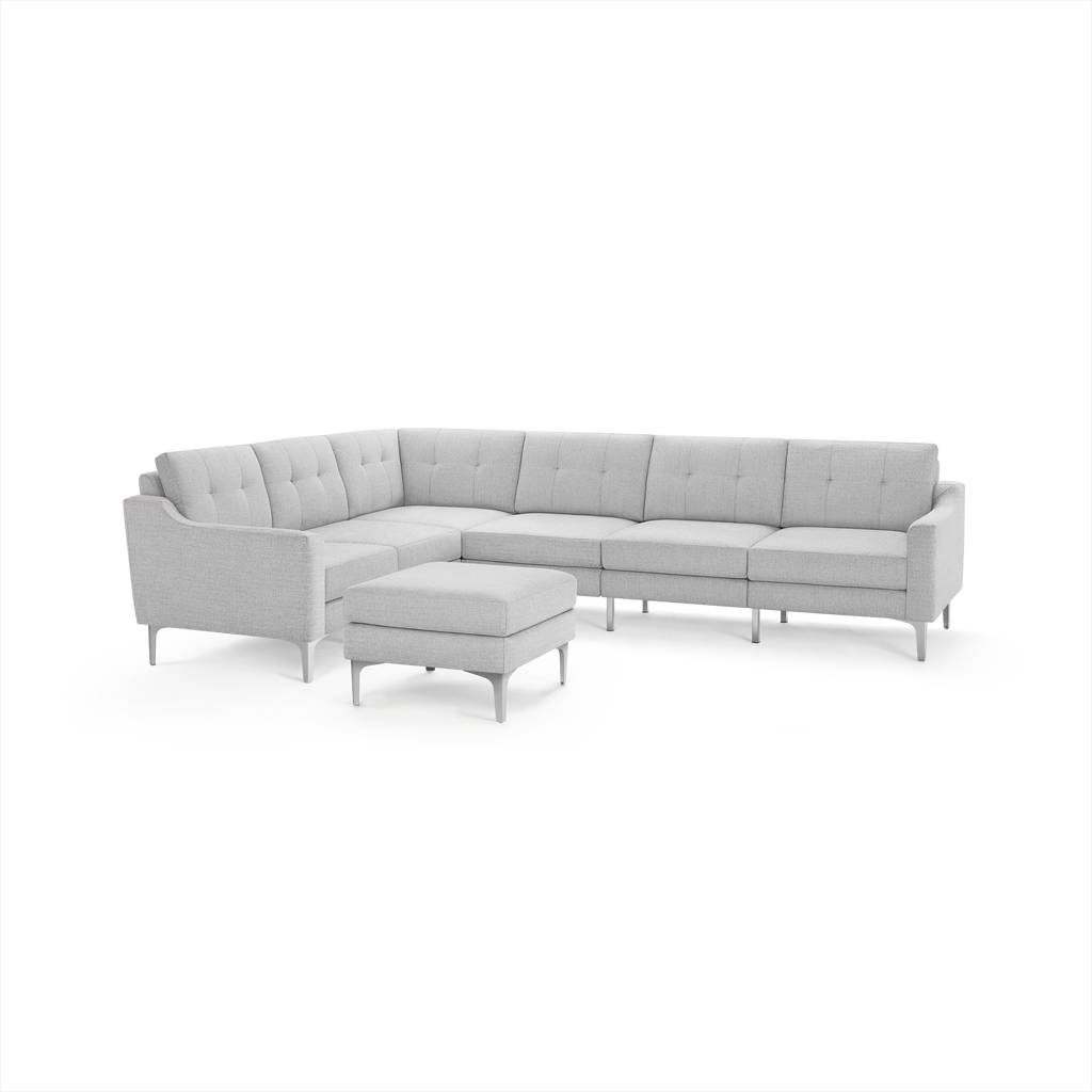 Light gray L-shaped sectional sofa with tufted cushions and metal legs, accompanied by a matching upholstered ottoman.