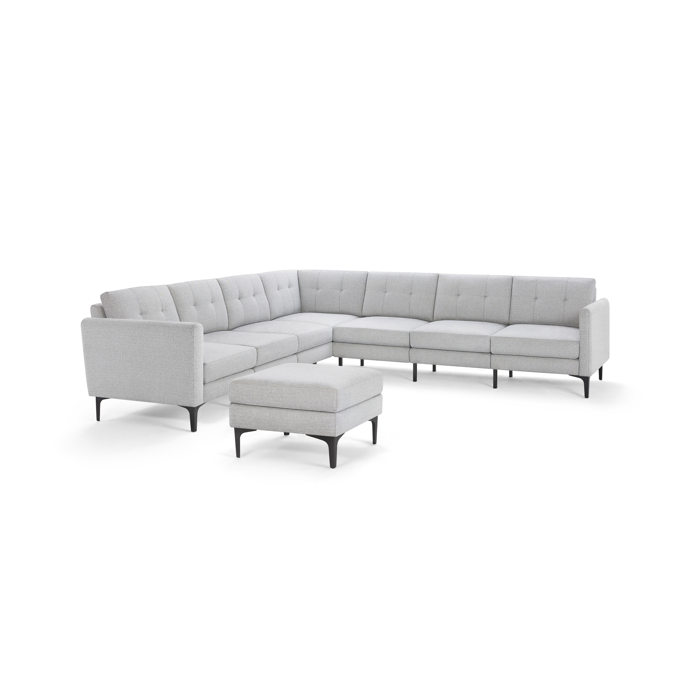 Light gray fabric upholstered modern sectional sofa with tufted cushions and matching ottoman on black legs.