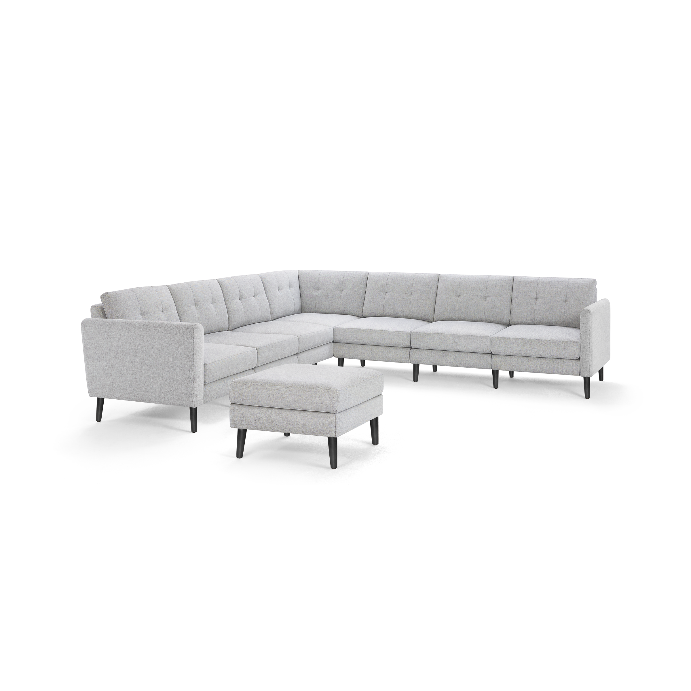 Light gray upholstered modern sectional sofa with button-tufted cushions and matching ottoman, supported by dark wooden legs.