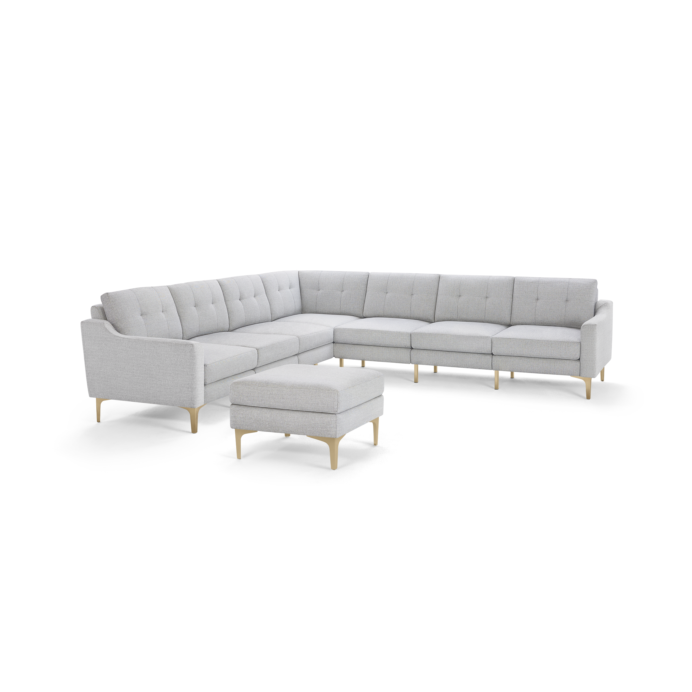 Light gray fabric L-shaped sectional sofa with tufted back cushions and matching ottoman, featuring wooden legs.