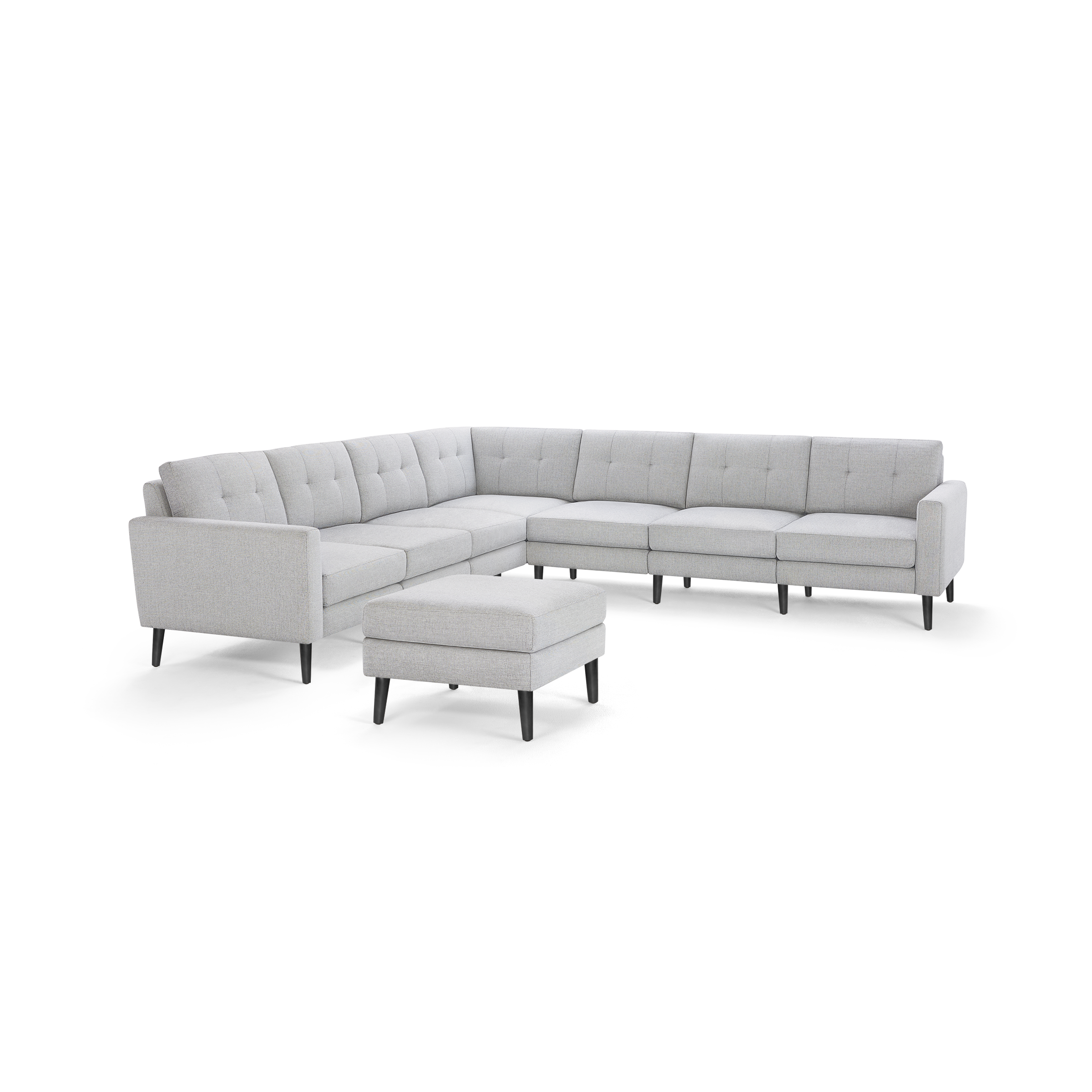 Light gray fabric sectional sofa with tufted back cushions, black tapered legs, and matching square ottoman.