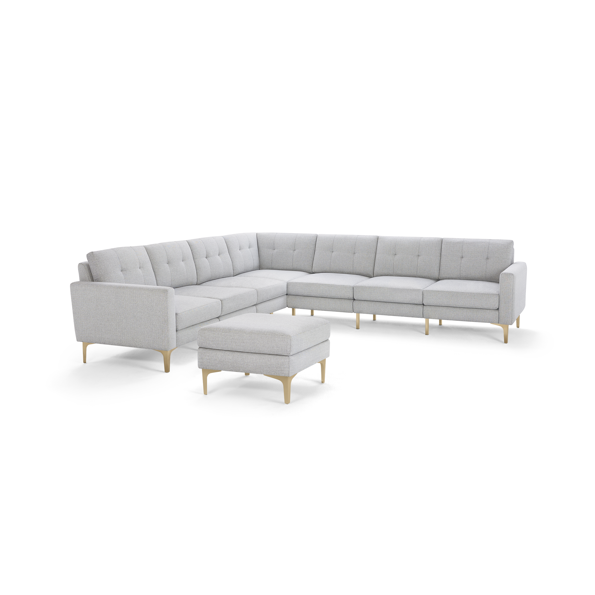 Light gray fabric L-shaped sectional sofa with tufted back cushions and matching ottoman, wooden legs.