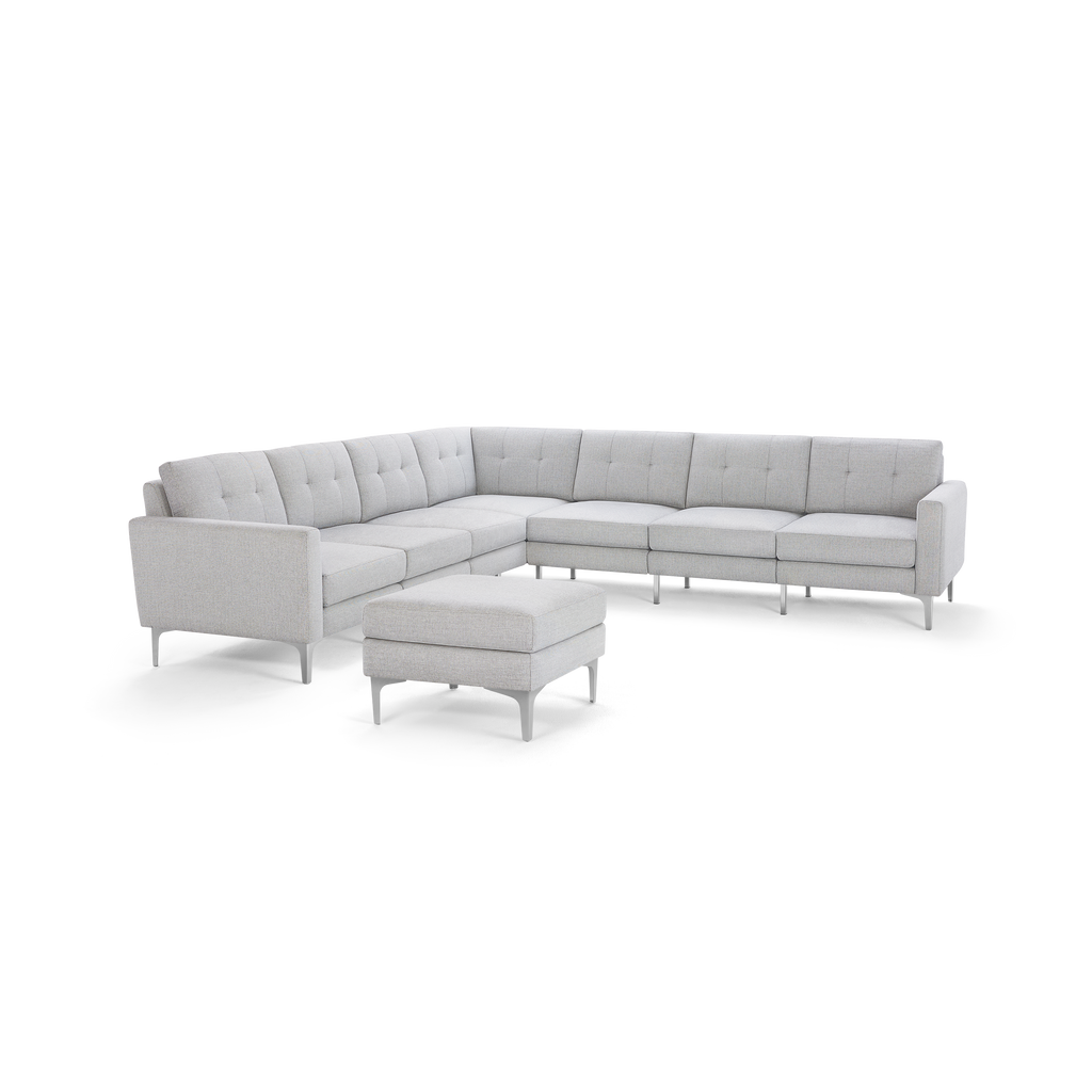 Light gray tufted fabric sectional sofa with metal legs and matching square ottoman.