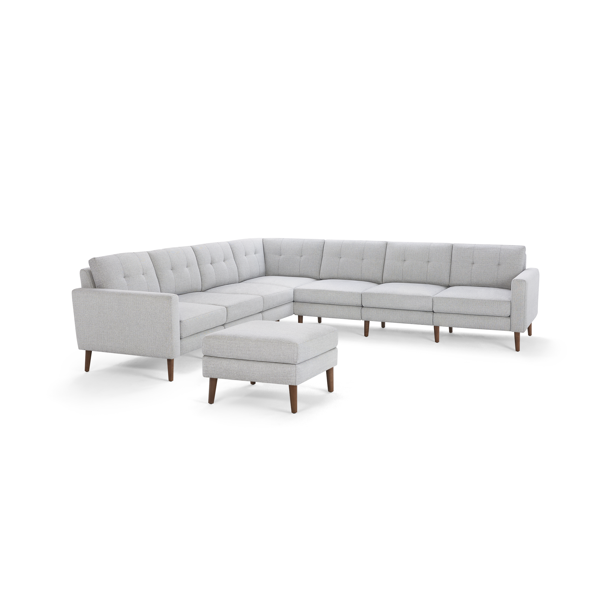 Light gray fabric sectional sofa with tufted back cushions, wooden legs, and a matching cushioned ottoman.