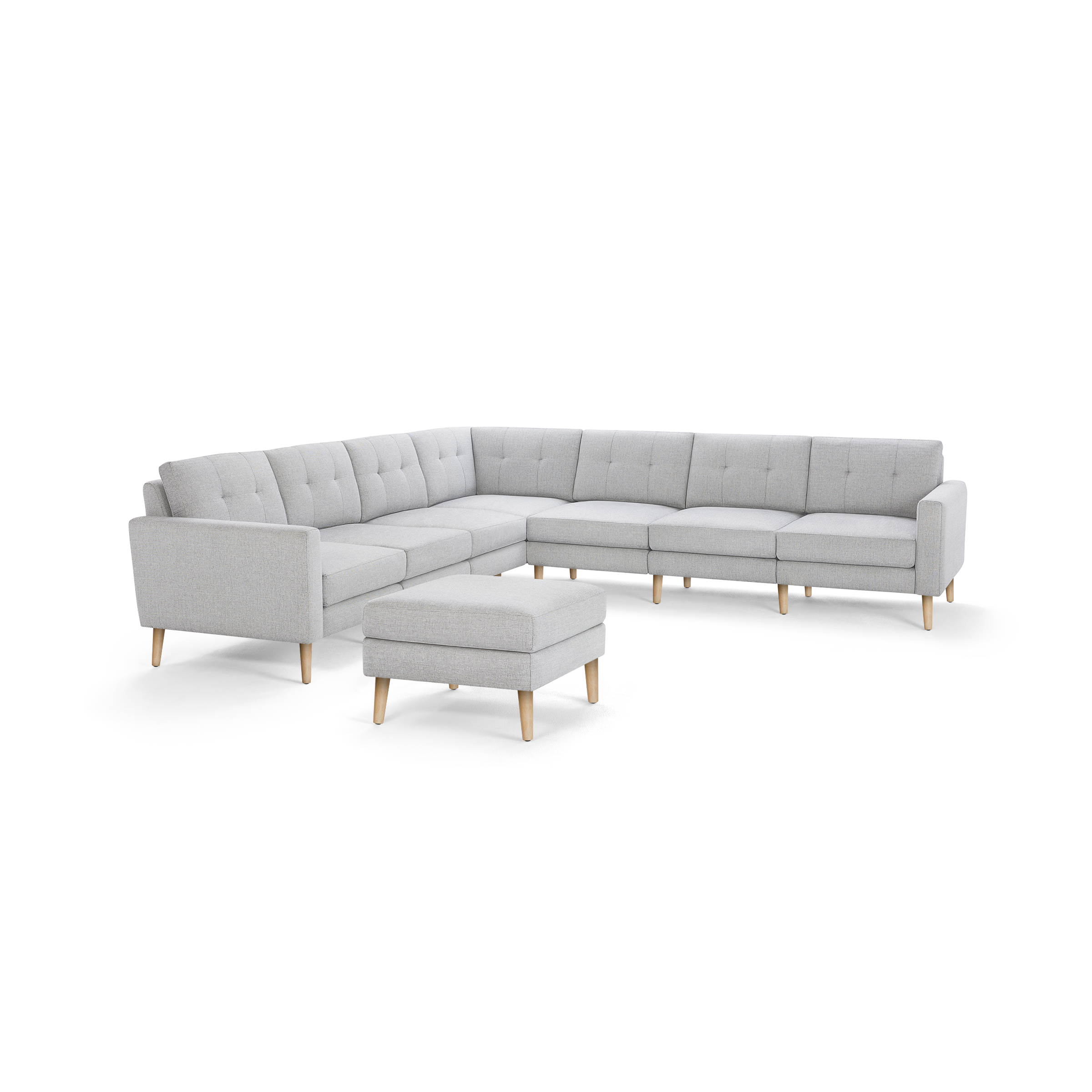 Light gray L-shaped sectional sofa with tufted cushions, wooden legs, and matching ottoman, modern minimalist design.