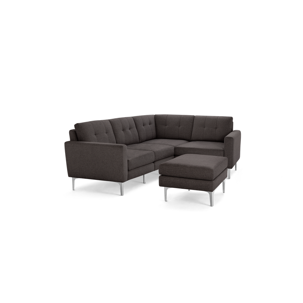Dark gray modern sectional sofa with tufted cushions and a matching ottoman, supported by sleek metal legs.