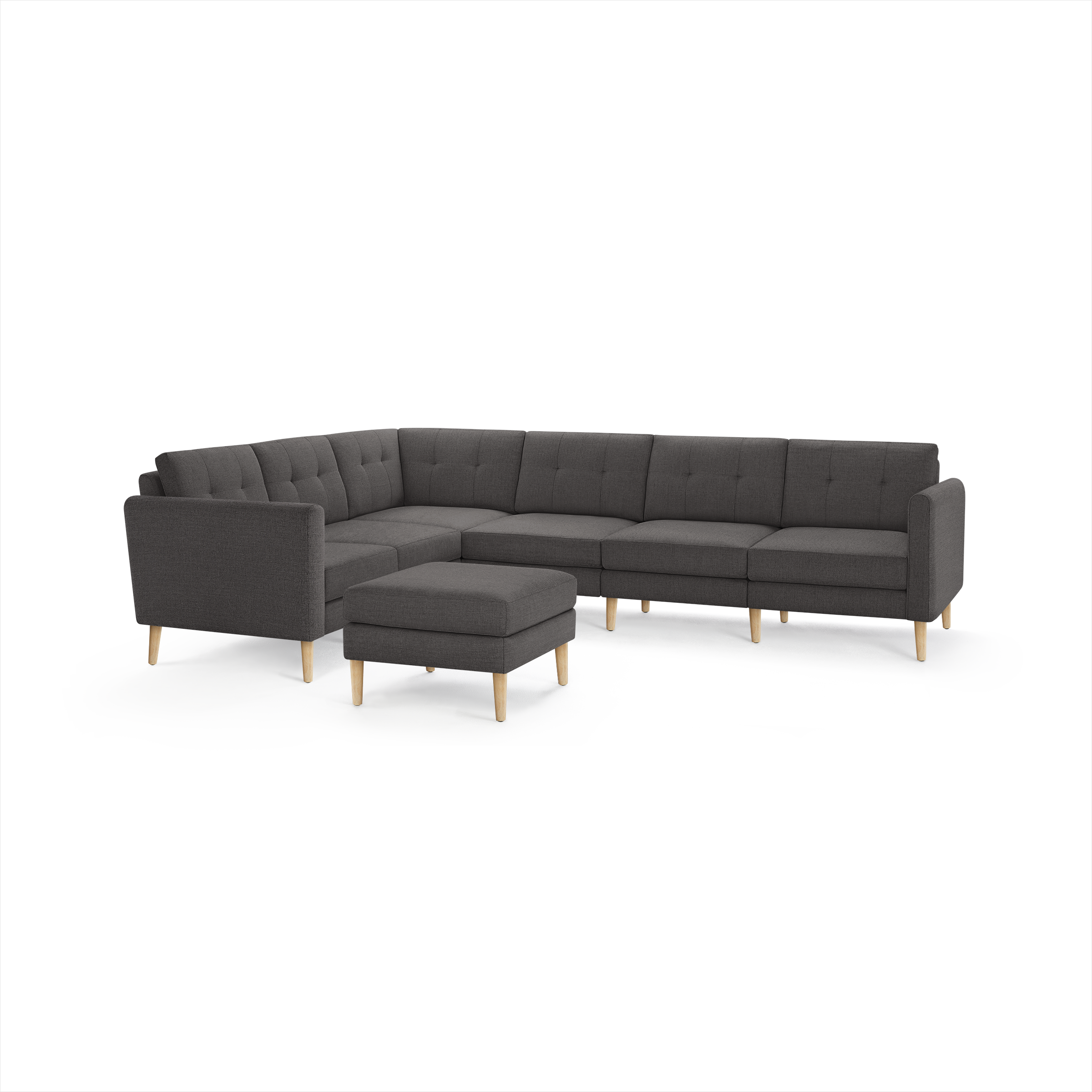Dark gray fabric L-shaped sectional sofa with tufted cushions and light wooden legs, including a matching ottoman.