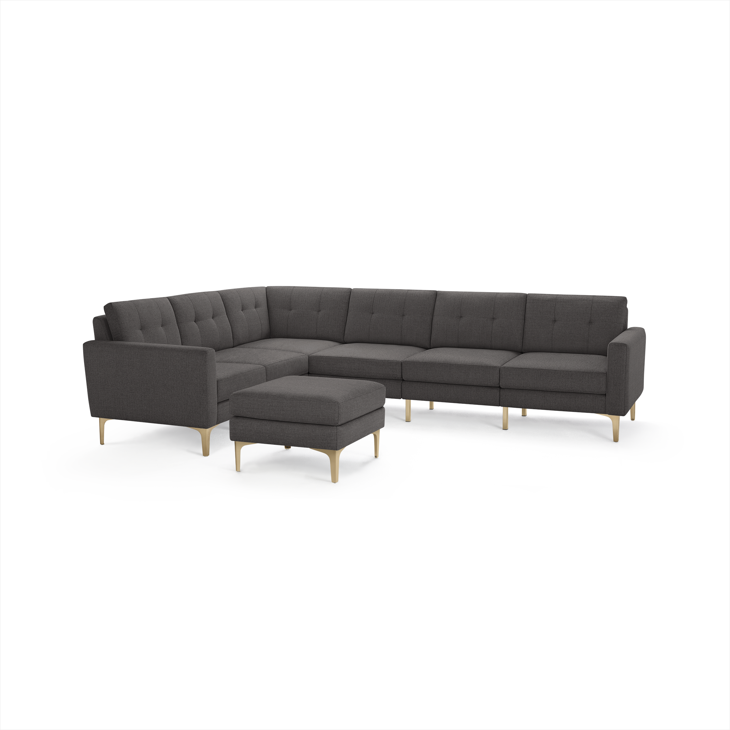Dark gray modern sectional sofa with tufted cushions, light wooden legs, and matching ottoman on white background.