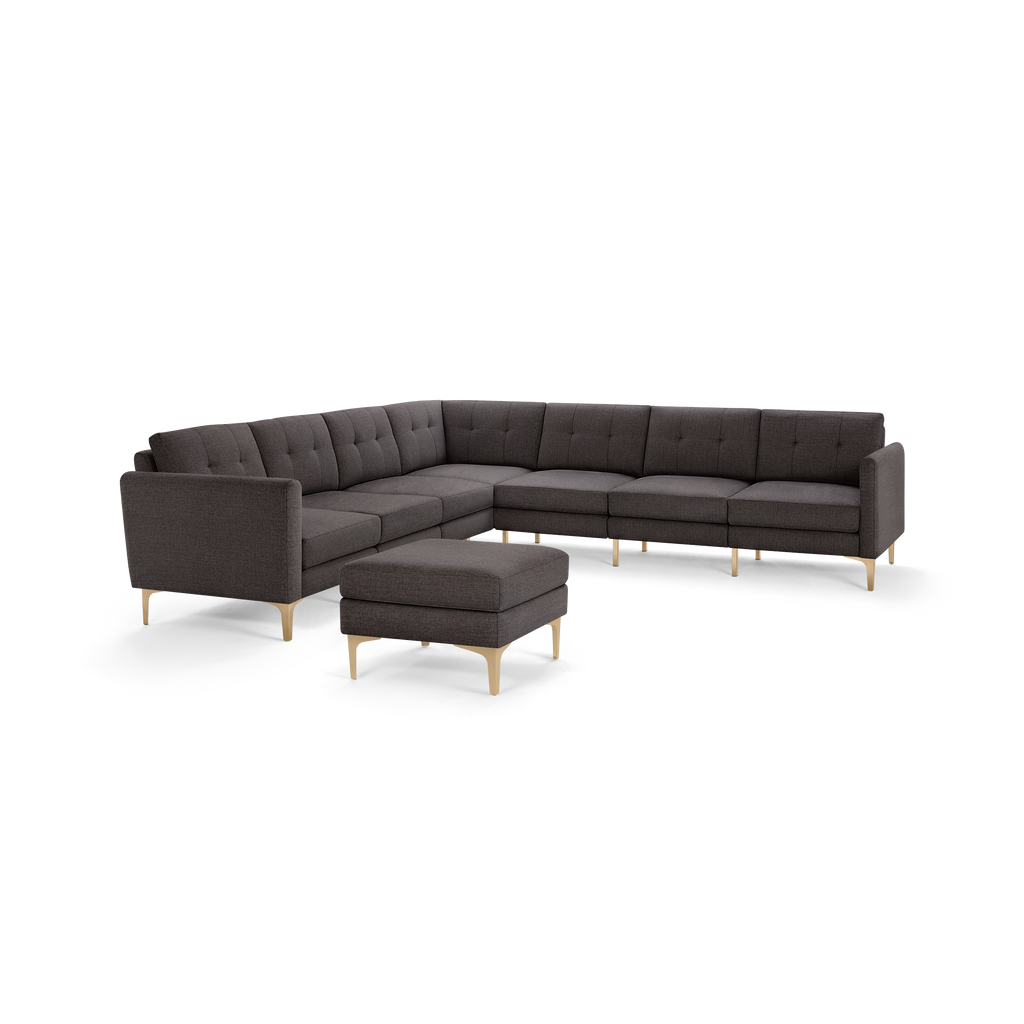 Dark gray modern sectional sofa with tufted cushions, wooden legs, and a matching square ottoman.